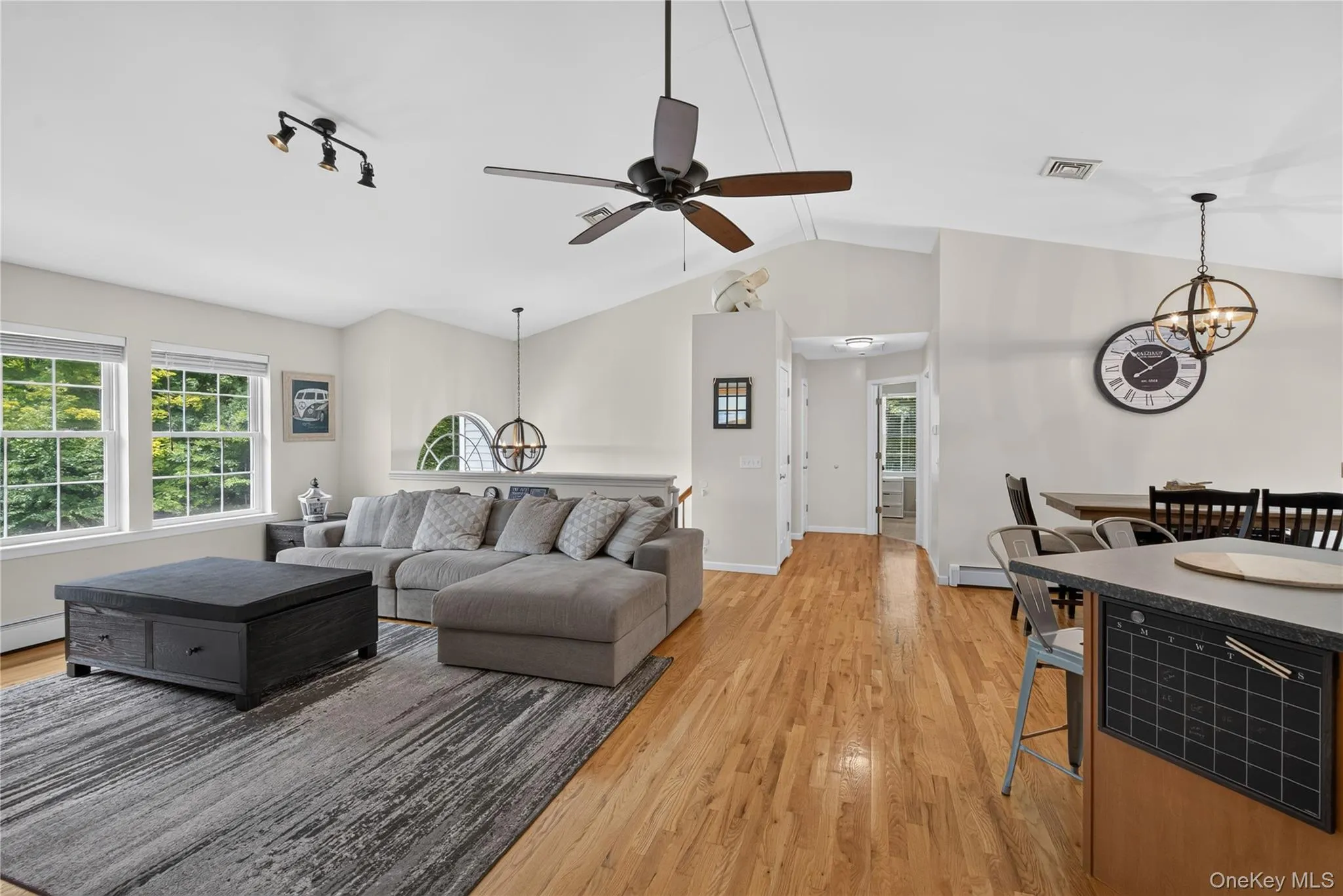 Vaulted ceilings, track lighting, ceiling fan, wood-finish flooring, and a built-in kitchen island Vaulted ceilings, track lighting, ceiling fan, wood-finish flooring, and a built-in kitchen island