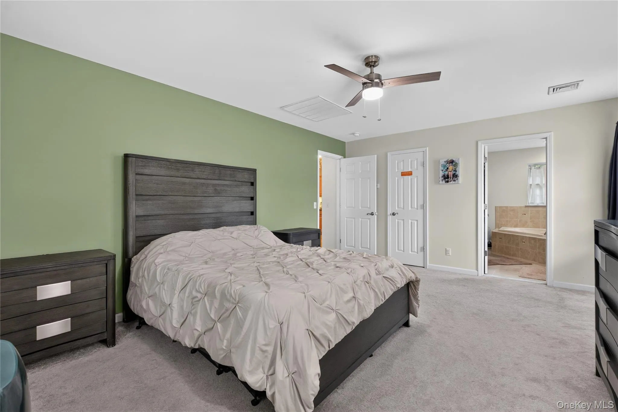 Plush carpeting, a ceiling fan with integrated lighting, and a neutral wall color with an accent wall Plush carpeting, a ceiling fan with integrated lighting, and a neutral wall color with an accent wall