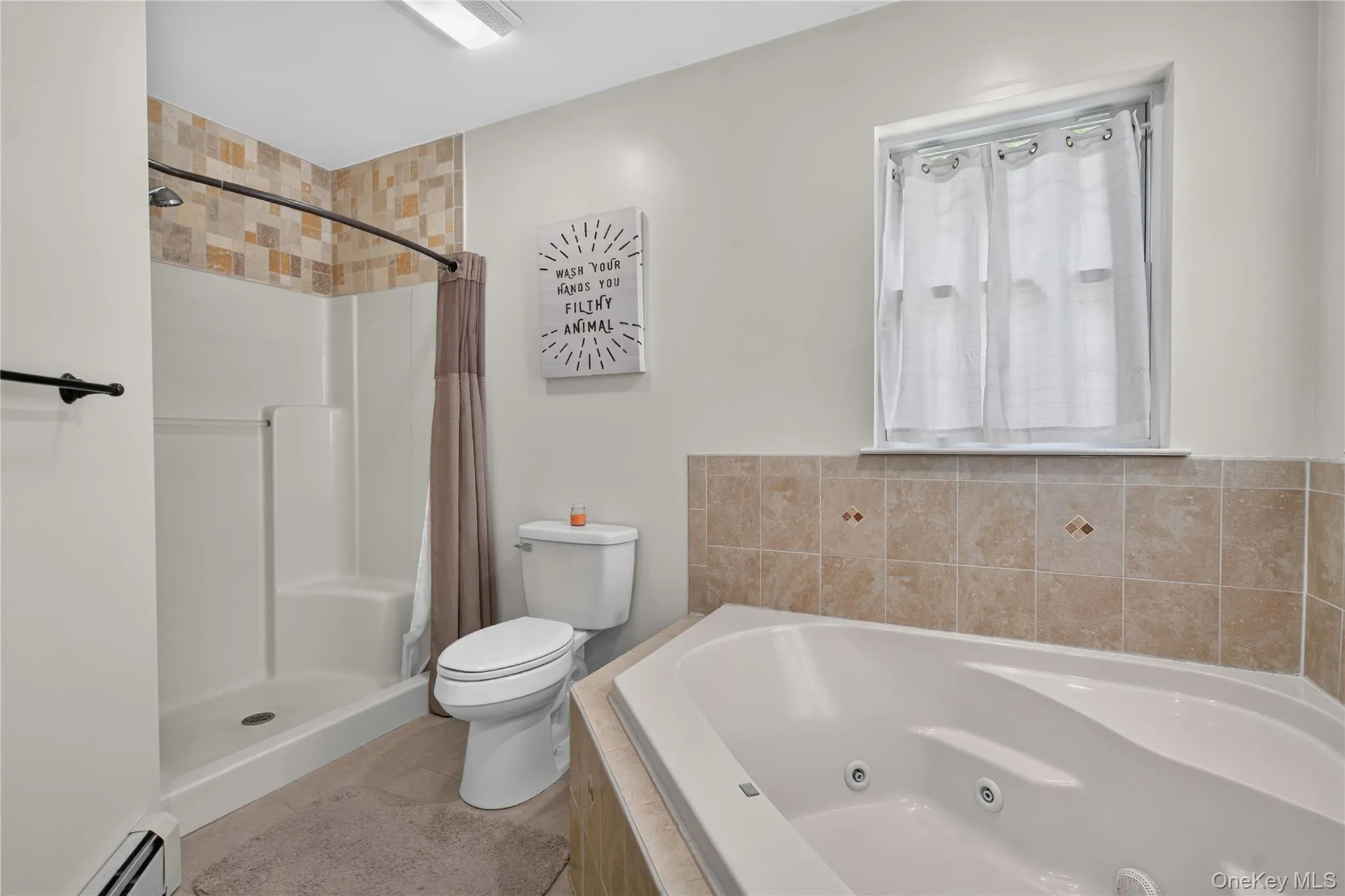 Walk-in shower with tiled surround, corner jetted tub, toilet, and tiled half-wall Walk-in shower with tiled surround, corner jetted tub, toilet, and tiled half-wall