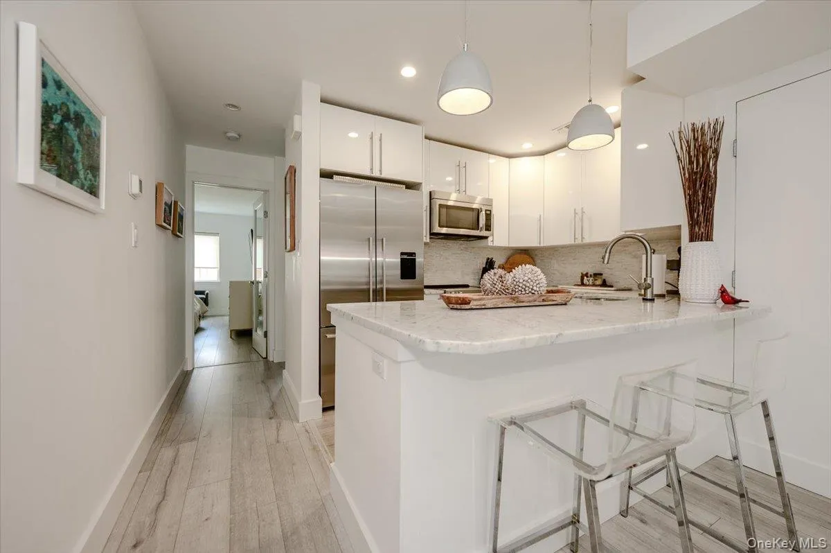 Open plan kitchen with Stainless appliances, Breakfast bar, Carrara Marble Counters Open plan kitchen with Stainless appliances, Breakfast bar, Carrara Marble Counters