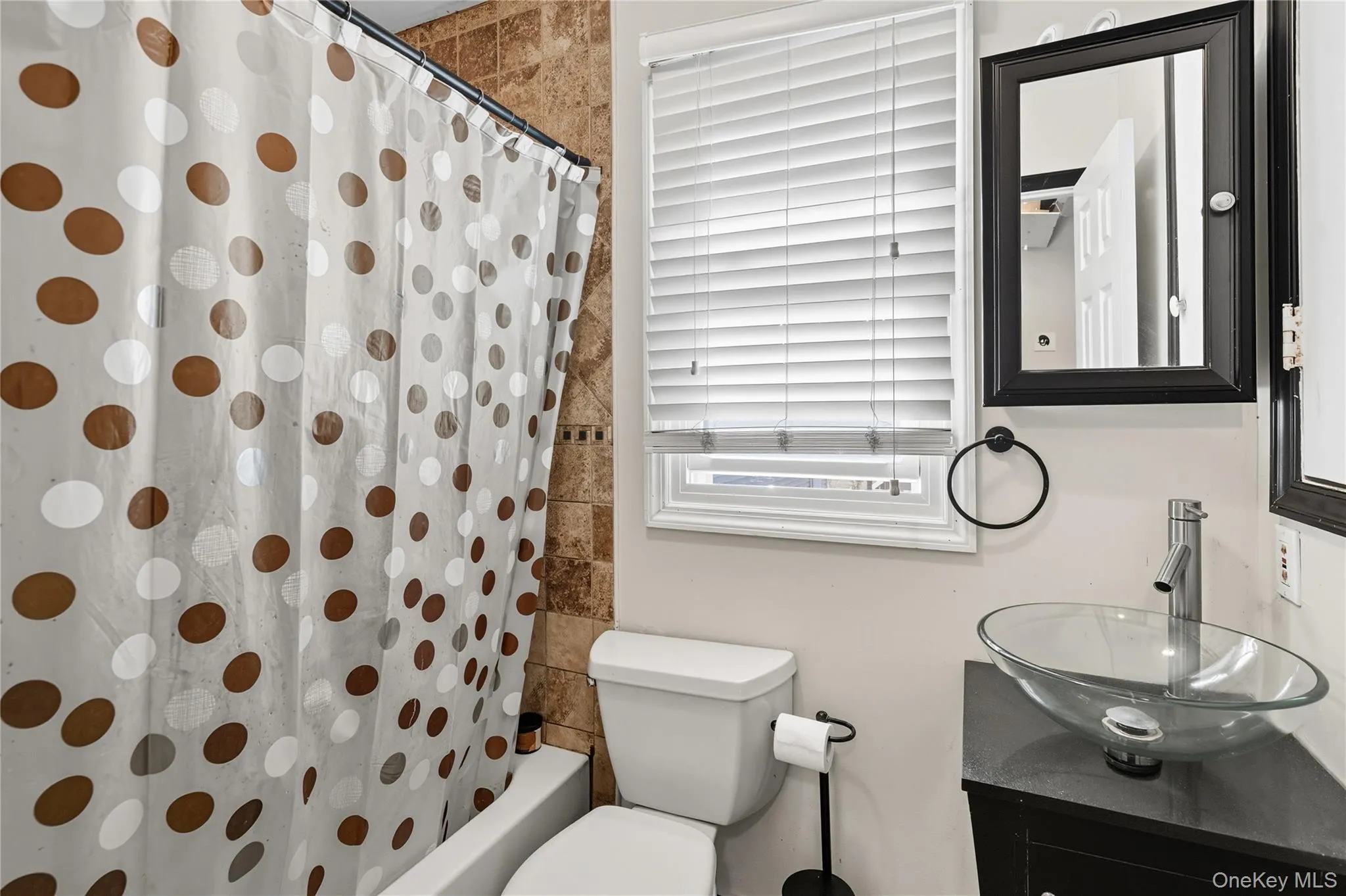 Full bathroom featuring vanity and shower / bath combination with curtain Full bathroom featuring vanity and shower / bath combination with curtain