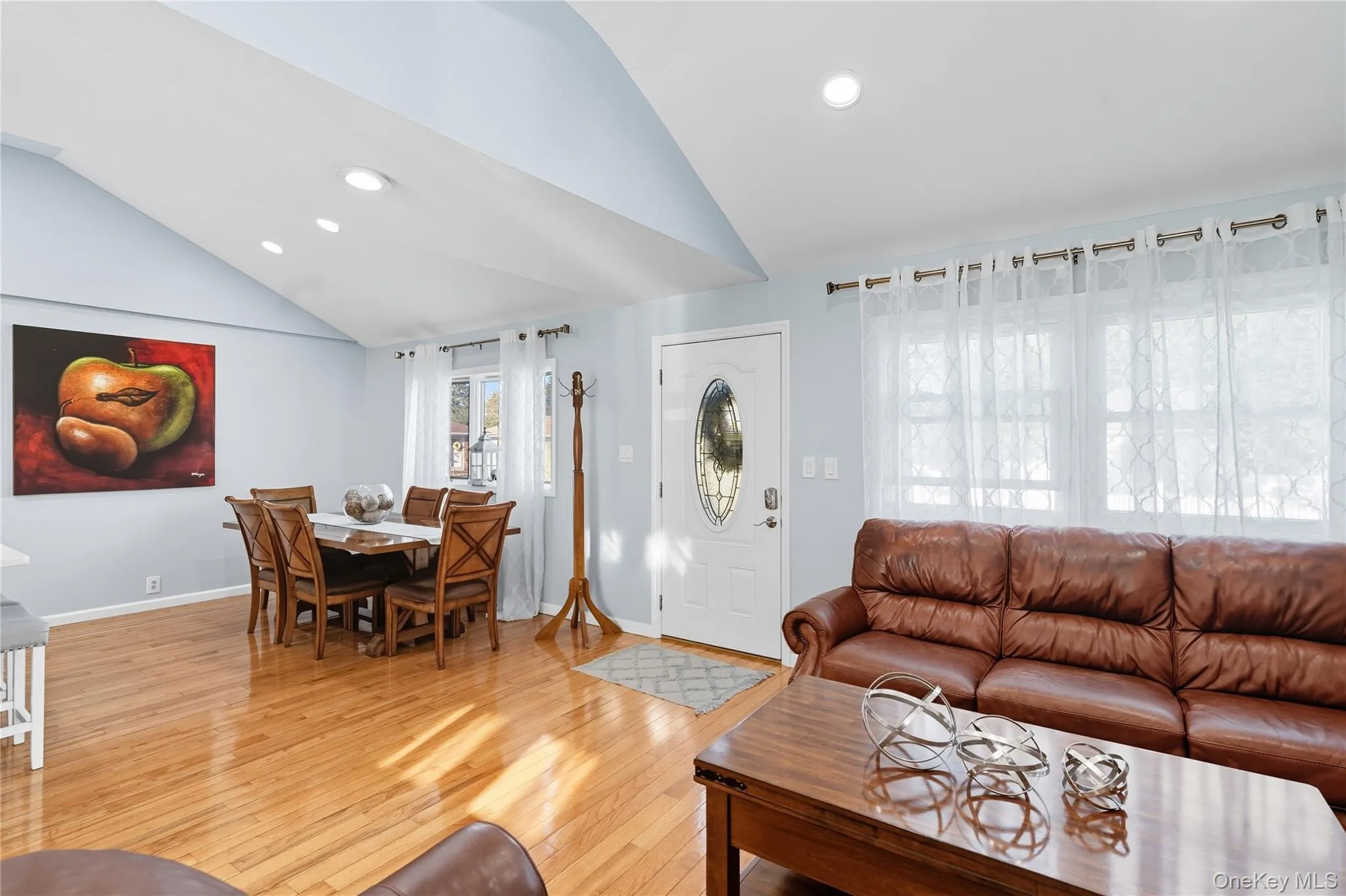 Living room with light wood-type flooring, recessed lighting, and high vaulted ceiling Living room with light wood-type flooring, recessed lighting, and high vaulted ceiling