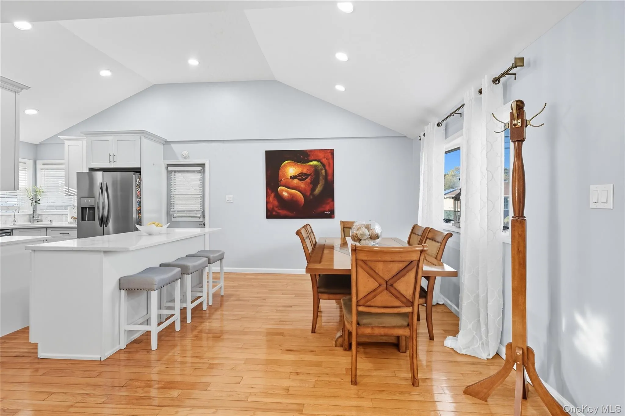 Dining space with light wood finished floors, vaulted ceiling, plenty of natural light, and recessed lighting Dining space with light wood finished floors, vaulted ceiling, plenty of natural light, and recessed lighting