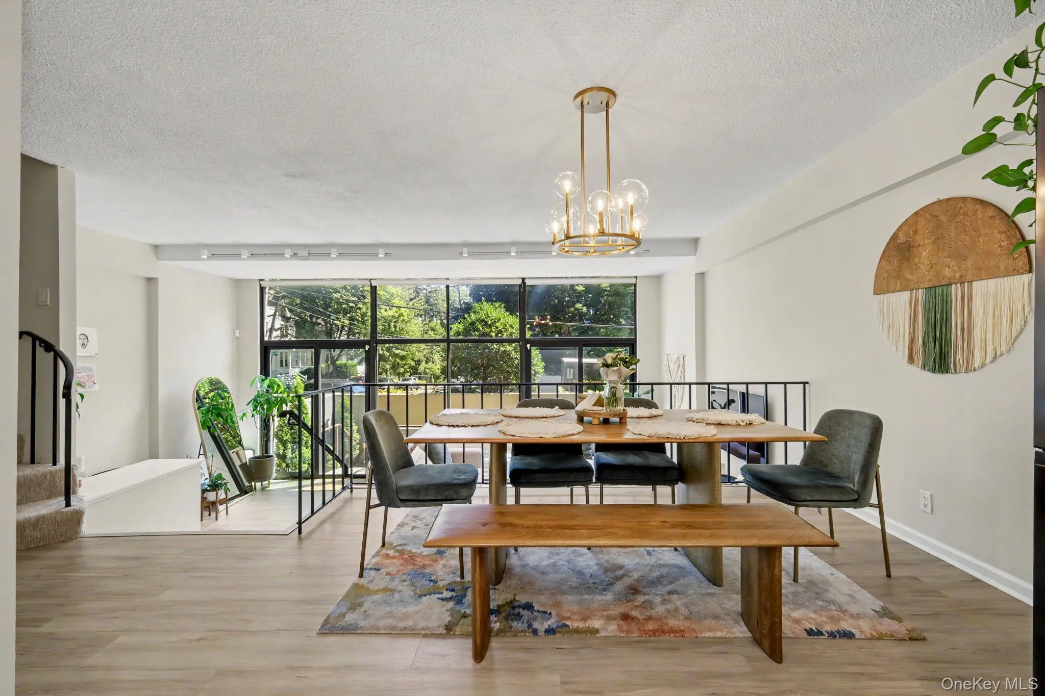 The sun-filled, two-story living room is a dramatic centerpiece of the home, featuring a soaring wall of glass and two sets of glass doors opening directly to the private terrace, creating a seamless connection between indoor and outdoor living. The sun-filled, two-story living room is a dramatic centerpiece of the home, featuring a soaring wall of glass and two sets of glass doors opening directly to the private terrace, creating a seamless connection between indoor and outdoor living.
