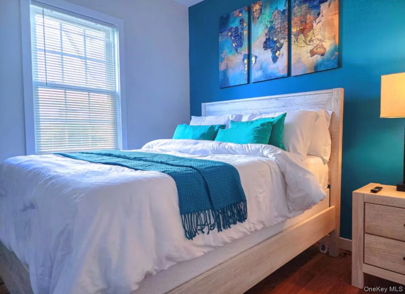 Hardwood-style flooring, a window with blinds, and a light-toned wooden headboard Hardwood-style flooring, a window with blinds, and a light-toned wooden headboard