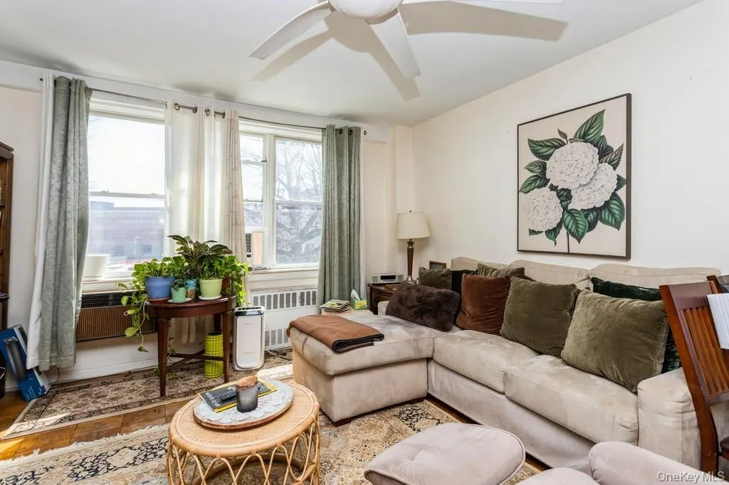 Living room featuring radiator heating unit and a ceiling fan Living room featuring radiator heating unit and a ceiling fan