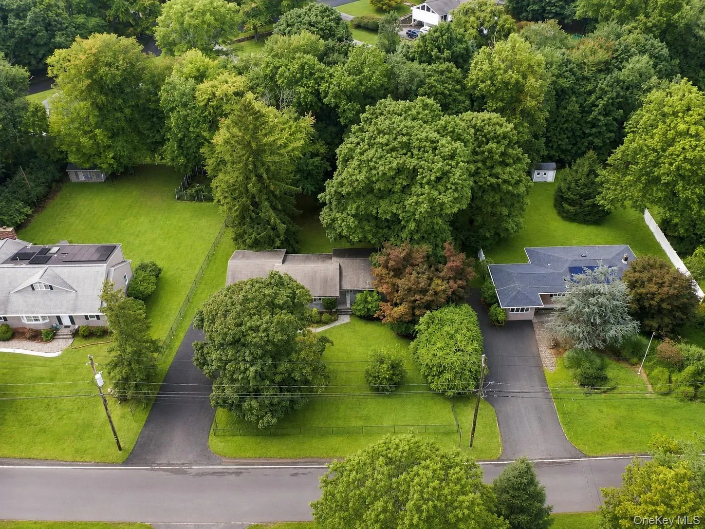 Expansive property featuring lush green lawns, mature trees, and paved driveways Expansive property featuring lush green lawns, mature trees, and paved driveways