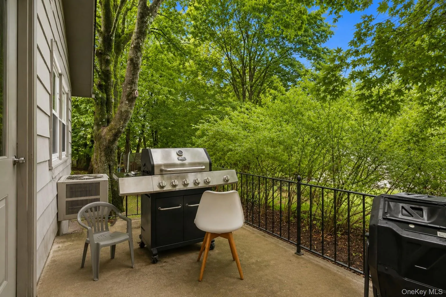Outdoor patio featuring a concrete surface and black metal railing Outdoor patio featuring a concrete surface and black metal railing