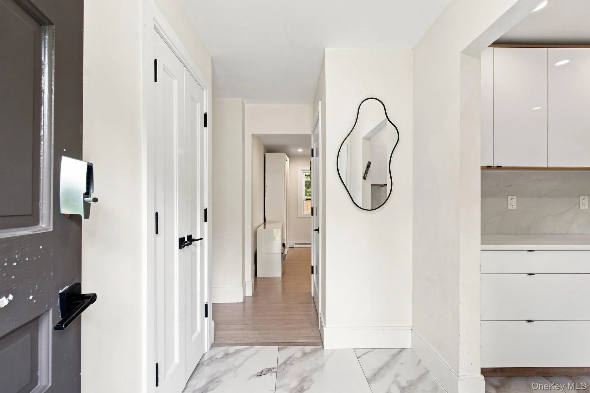 Marble-style tile flooring, white interior doors with black hardware Marble-style tile flooring, white interior doors with black hardware