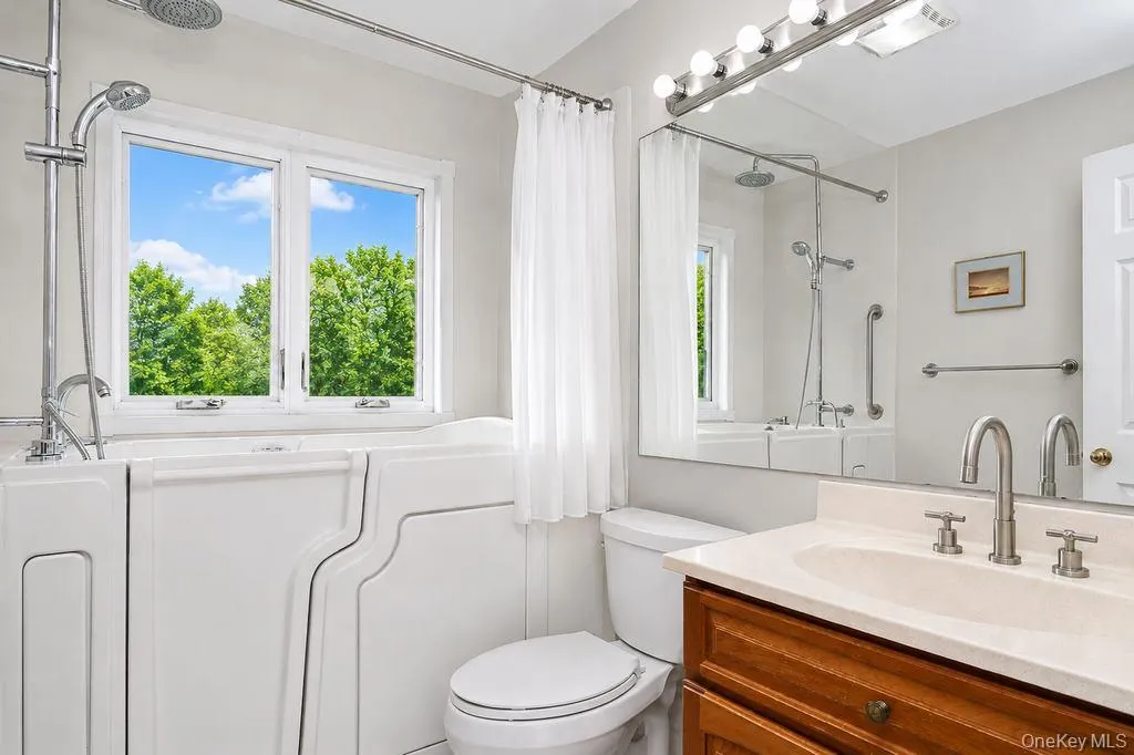 Primary Bathroom has sink with vanity and step-in jacuzzi with shower Primary Bathroom has sink with vanity and step-in jacuzzi with shower
