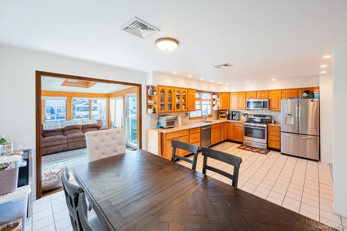 Kitchen with appliances with stainless steel finishes, light tile patterned floors, a healthy amount of sunlight, and sink Kitchen with appliances with stainless steel finishes, light tile patterned floors, a healthy amount of sunlight, and sink