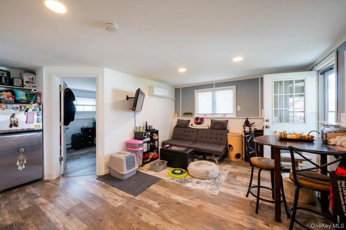 Living room with hardwood / wood-style floors and a wall unit AC Living room with hardwood / wood-style floors and a wall unit AC