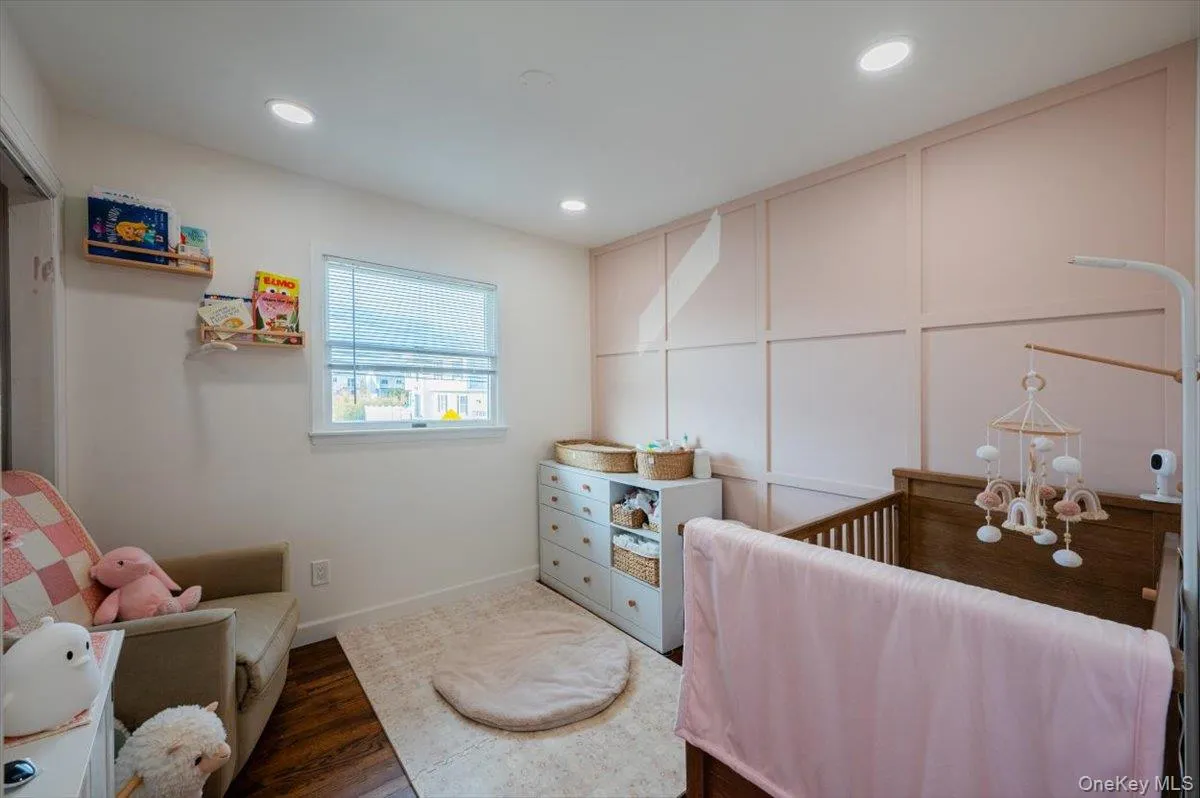 Bedroom featuring a chandelier, dark hardwood / wood-style floors, and a crib Bedroom featuring a chandelier, dark hardwood / wood-style floors, and a crib