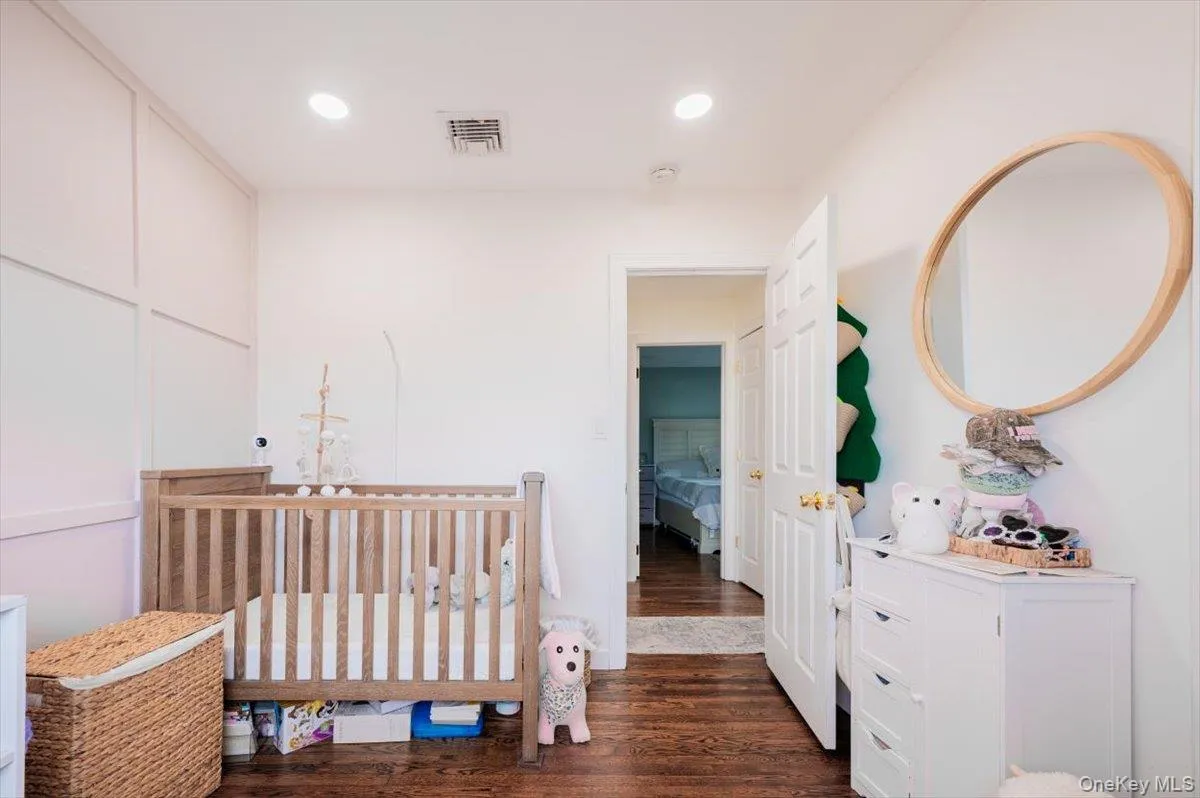 Bedroom featuring a crib and dark hardwood / wood-style flooring Bedroom featuring a crib and dark hardwood / wood-style flooring