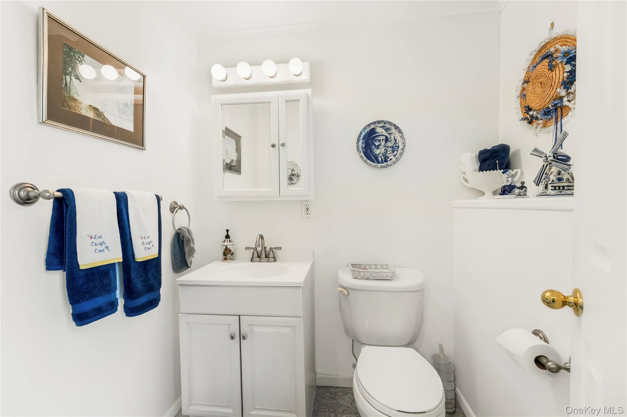 White vanity with integrated sink, chrome faucet, medicine cabinet, and overhead four-bulb light fixture White vanity with integrated sink, chrome faucet, medicine cabinet, and overhead four-bulb light fixture