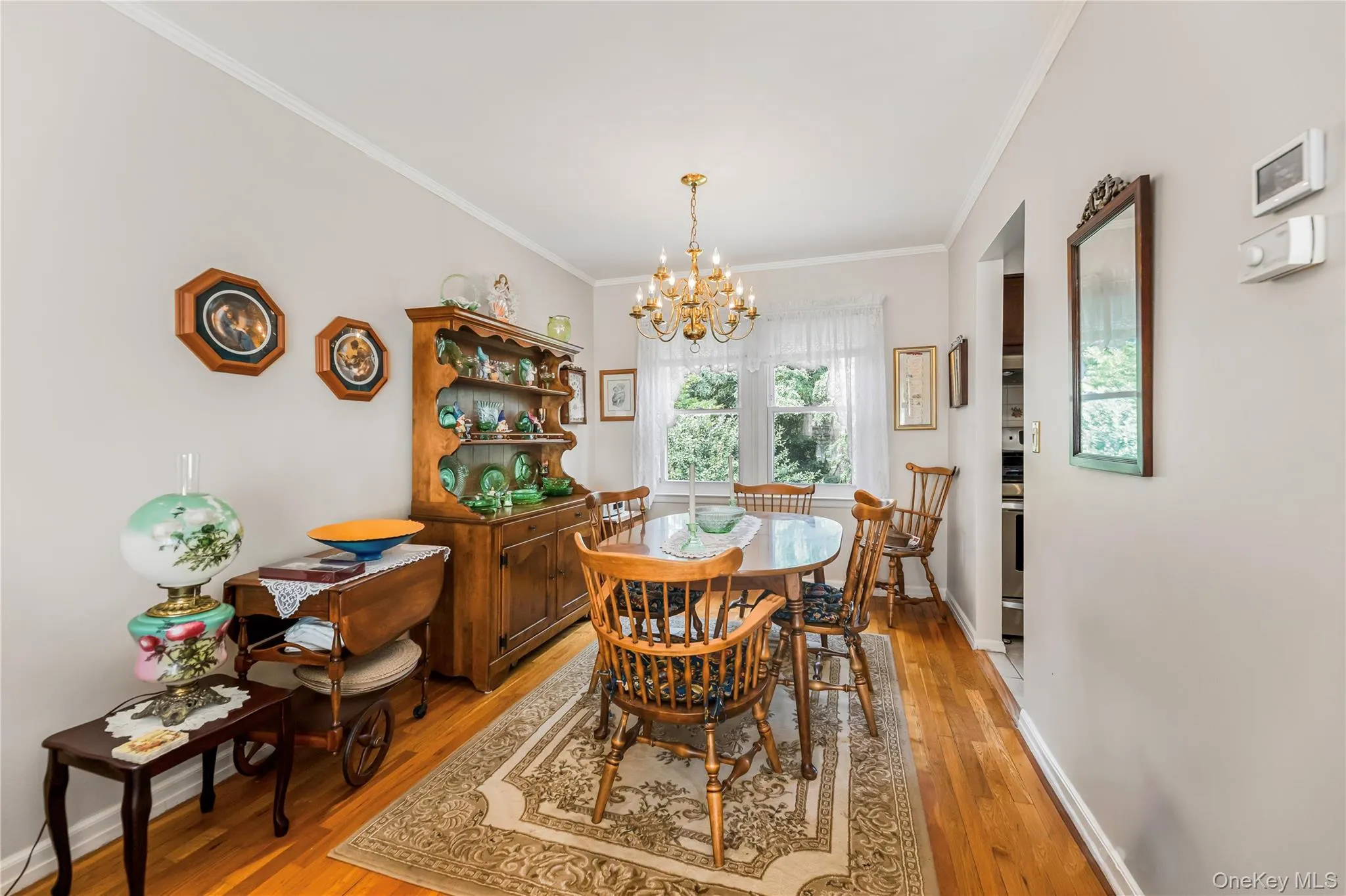 Hardwood flooring, crown molding, and a chandelier illuminate the dining area Hardwood flooring, crown molding, and a chandelier illuminate the dining area