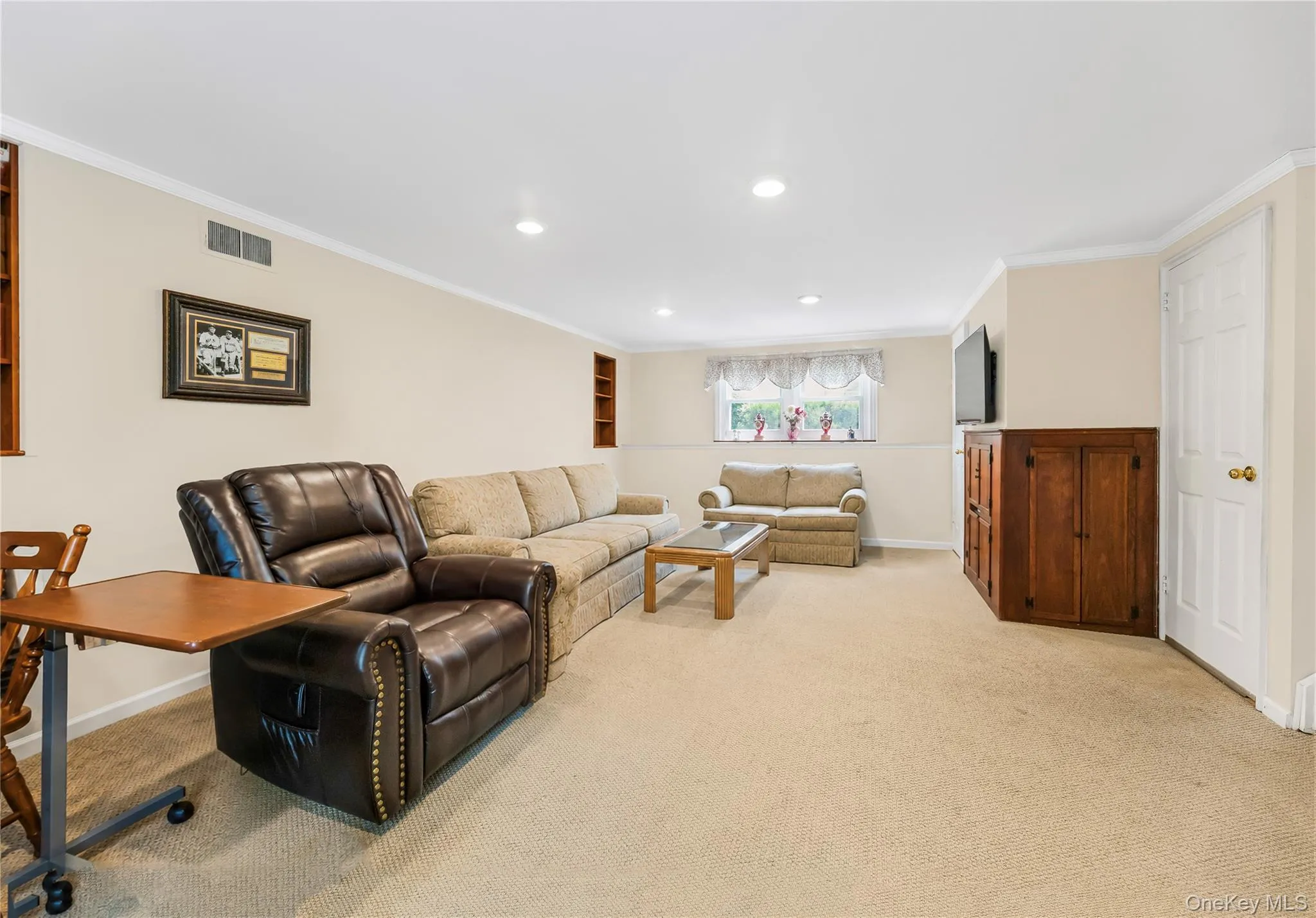 Recessed ceiling lighting, crown molding, built-in shelving, carpet flooring, and a window with natural light Recessed ceiling lighting, crown molding, built-in shelving, carpet flooring, and a window with natural light