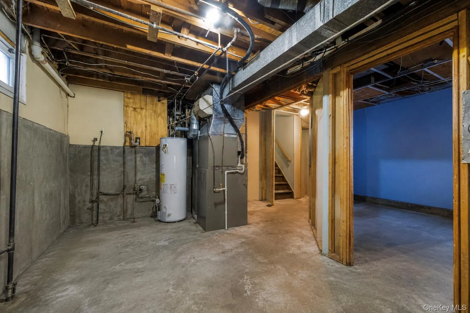Concrete flooring, concrete perimeter walls, exposed ceiling joists, utility water heater, and a furnace system Concrete flooring, concrete perimeter walls, exposed ceiling joists, utility water heater, and a furnace system