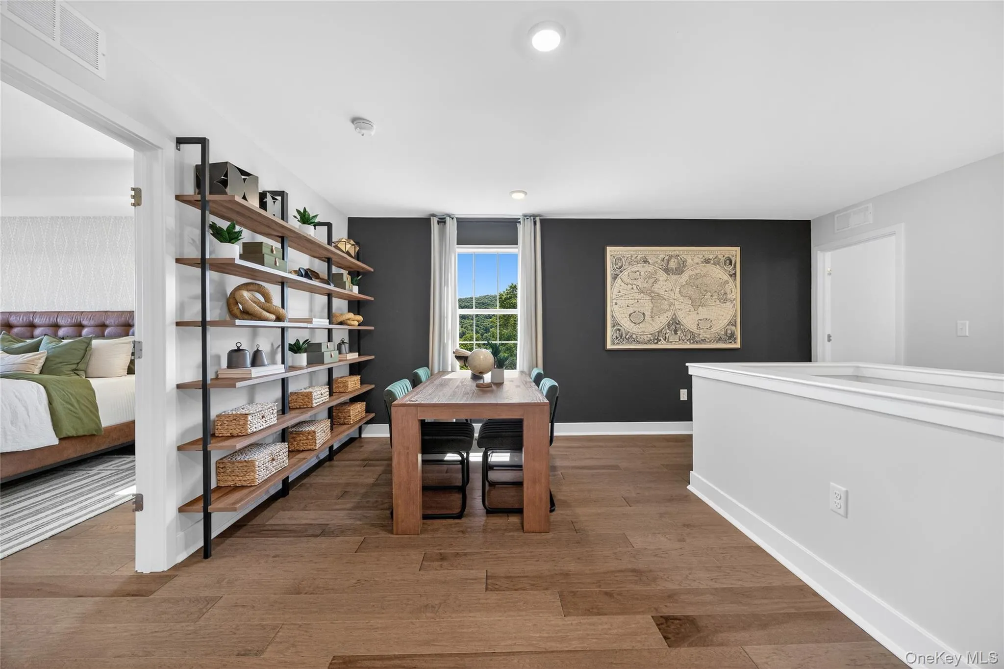 Open concept loft featuring a full-height built-in shelving unit, and a window with natural light. Open concept loft featuring a full-height built-in shelving unit, and a window with natural light.