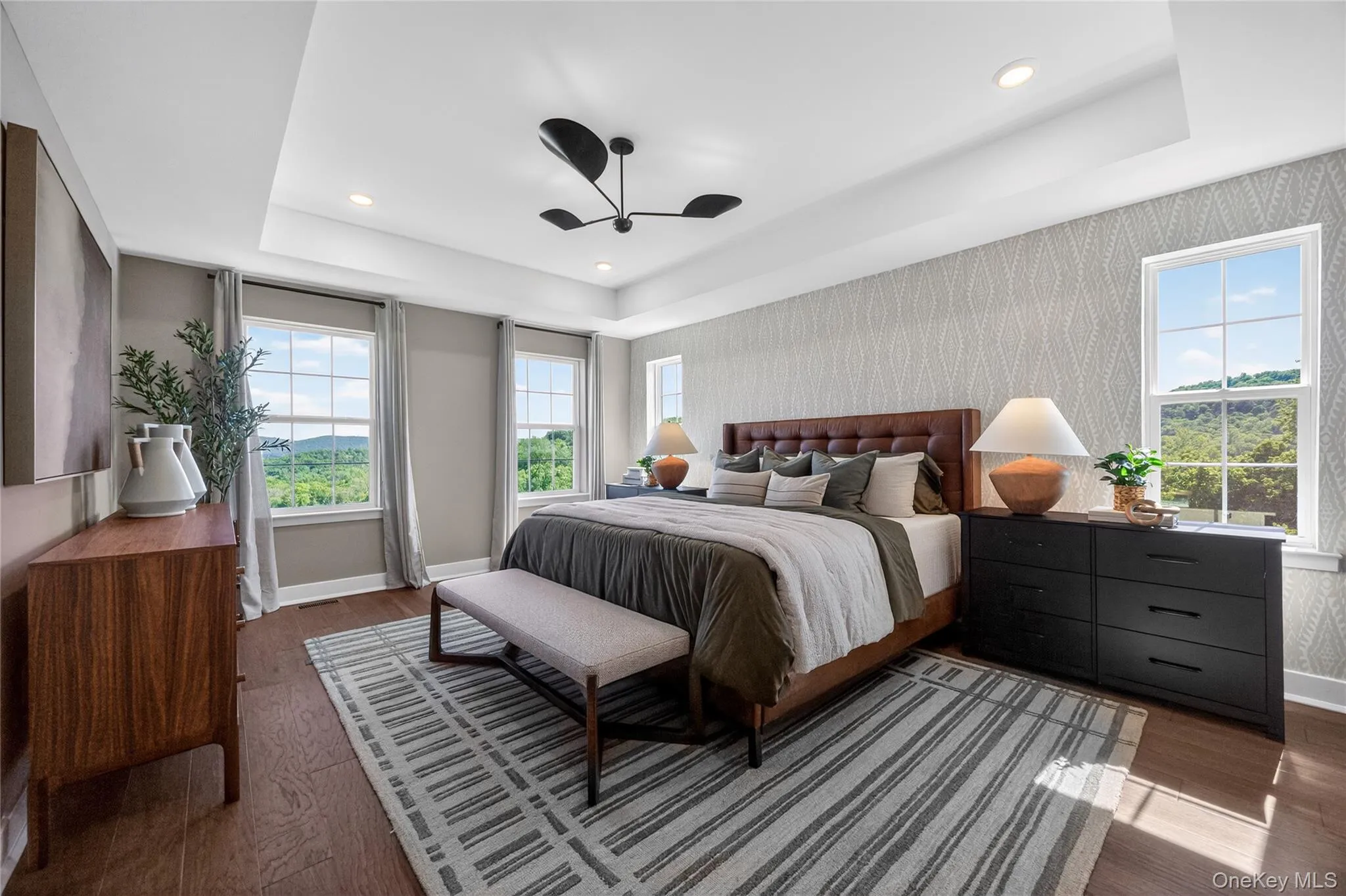 Spacious primary bedroom featuring a tray ceiling. Spacious primary bedroom featuring a tray ceiling.