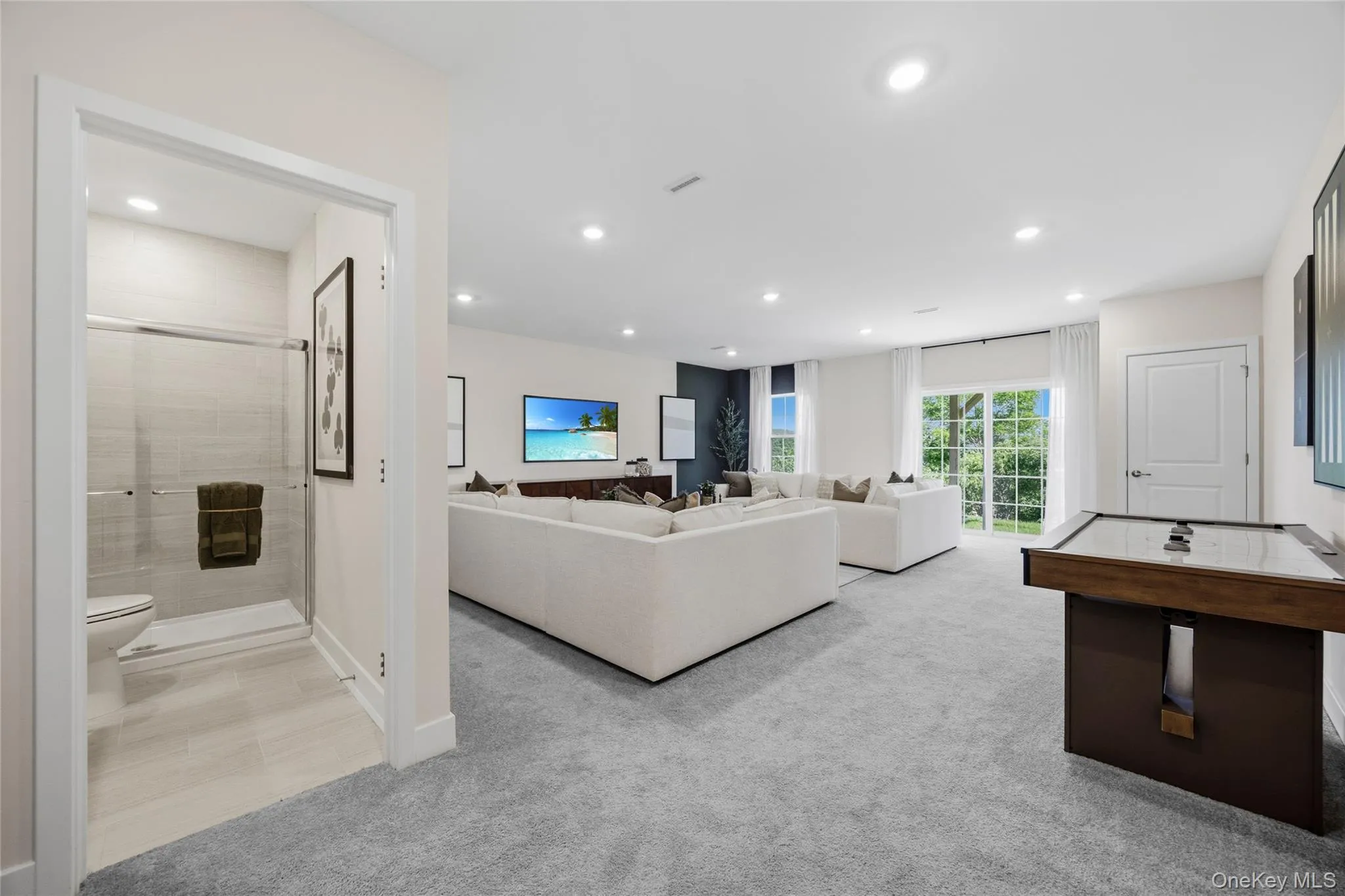 Spacious finished walkout basement with plush gray carpeting, recessed lighting, and a sliding glass door leading to outdoor space. Spacious finished walkout basement with plush gray carpeting, recessed lighting, and a sliding glass door leading to outdoor space.