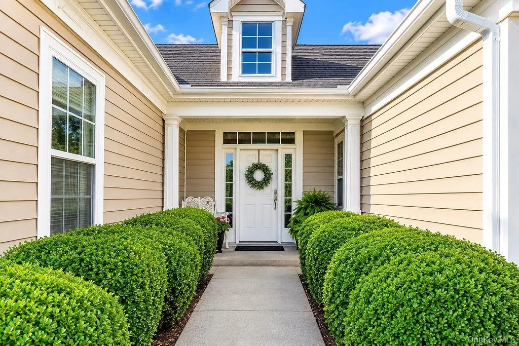 Covered entry framed by manicured Boxwoods Covered entry framed by manicured Boxwoods
