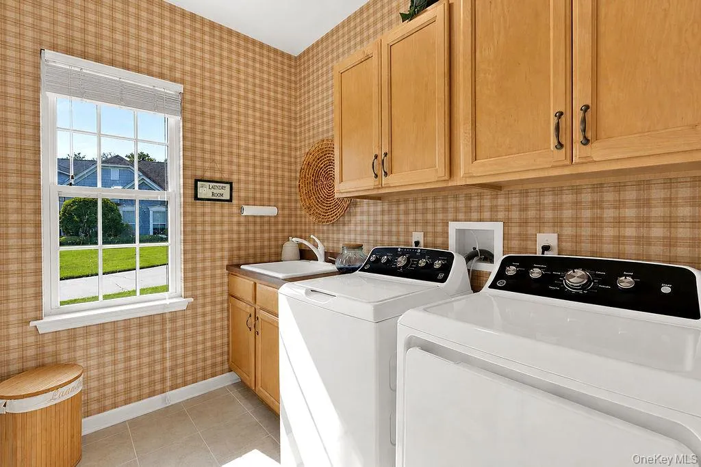Separate laundry room with utility sink and storage cabinetry Separate laundry room with utility sink and storage cabinetry