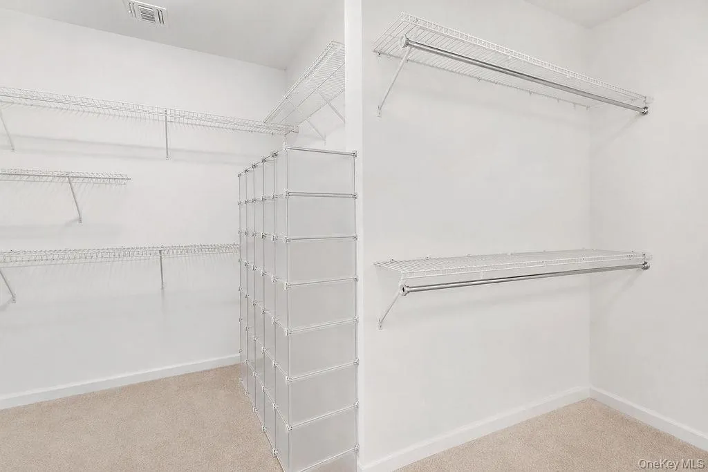 Spacious walk-in closet - virtually decluttered Spacious walk-in closet - virtually decluttered