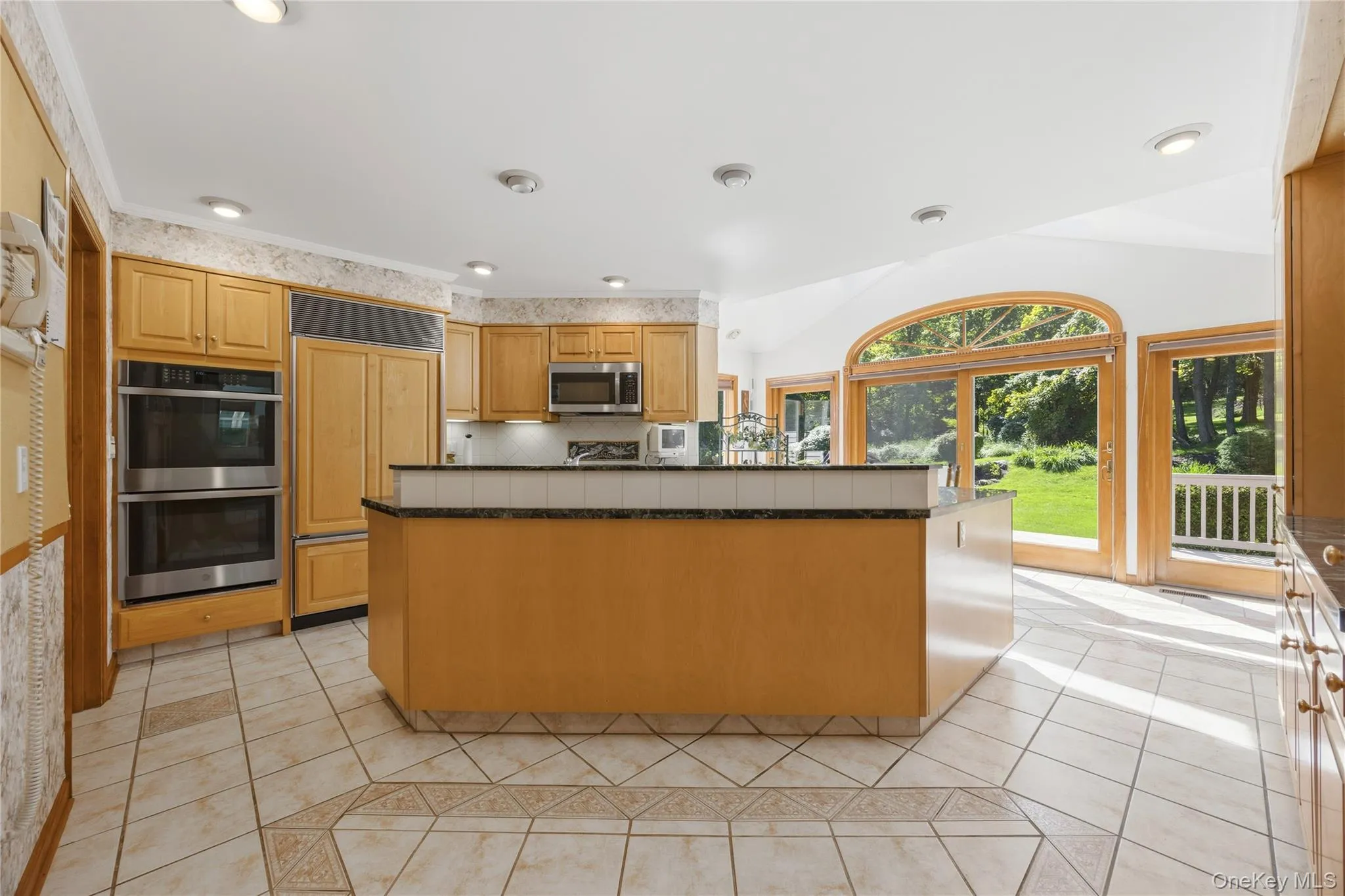The expansive Center Island and view of Kitchen through to the Deck and backyard. The expansive Center Island and view of Kitchen through to the Deck and backyard.
