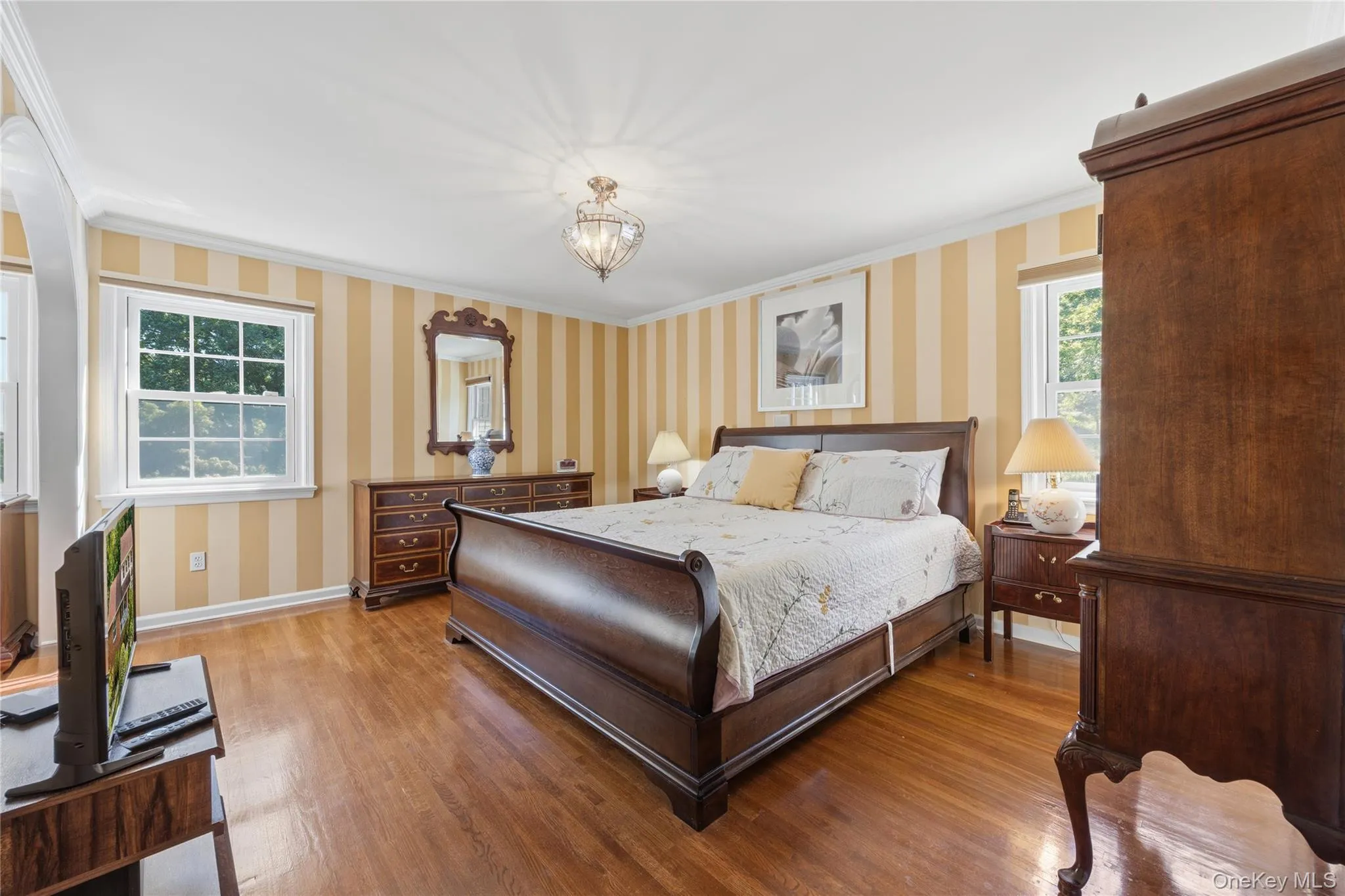 Two options for primary suites: here is one. A 1st Floor Primary Bedroom Suite with archway, hardwood floors, and walk-in closet plus a private full Bathroom Two options for primary suites: here is one. A 1st Floor Primary Bedroom Suite with archway, hardwood floors, and walk-in closet plus a private full Bathroom