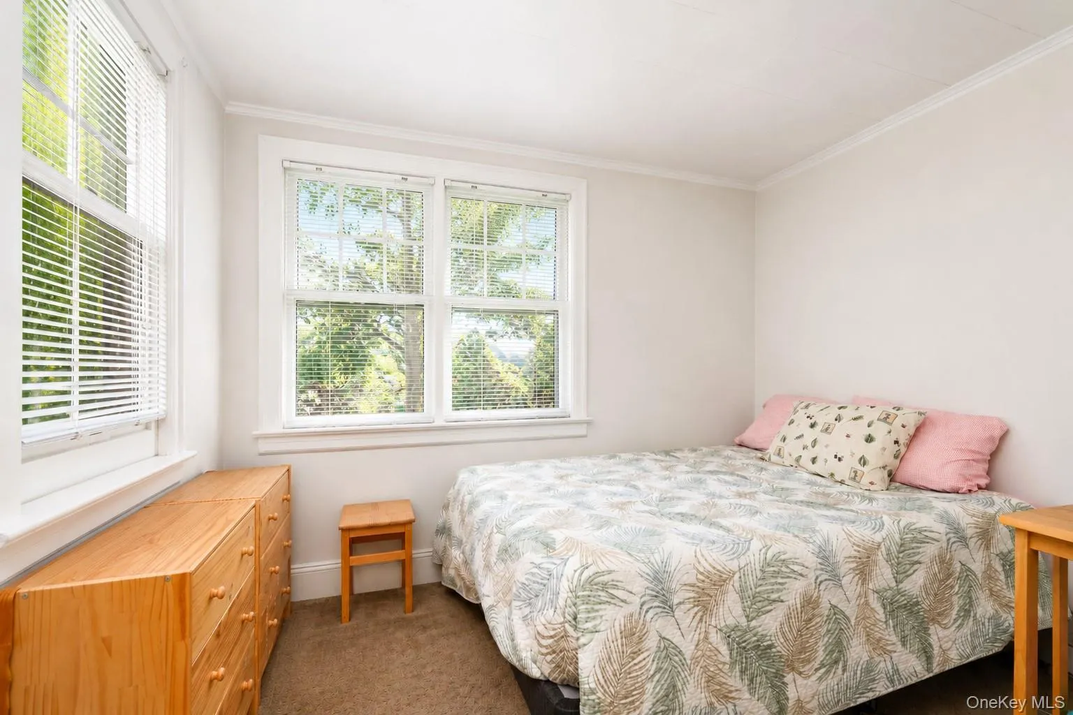 Double-hung windows with white blinds, crown molding, and neutral wall paint Double-hung windows with white blinds, crown molding, and neutral wall paint