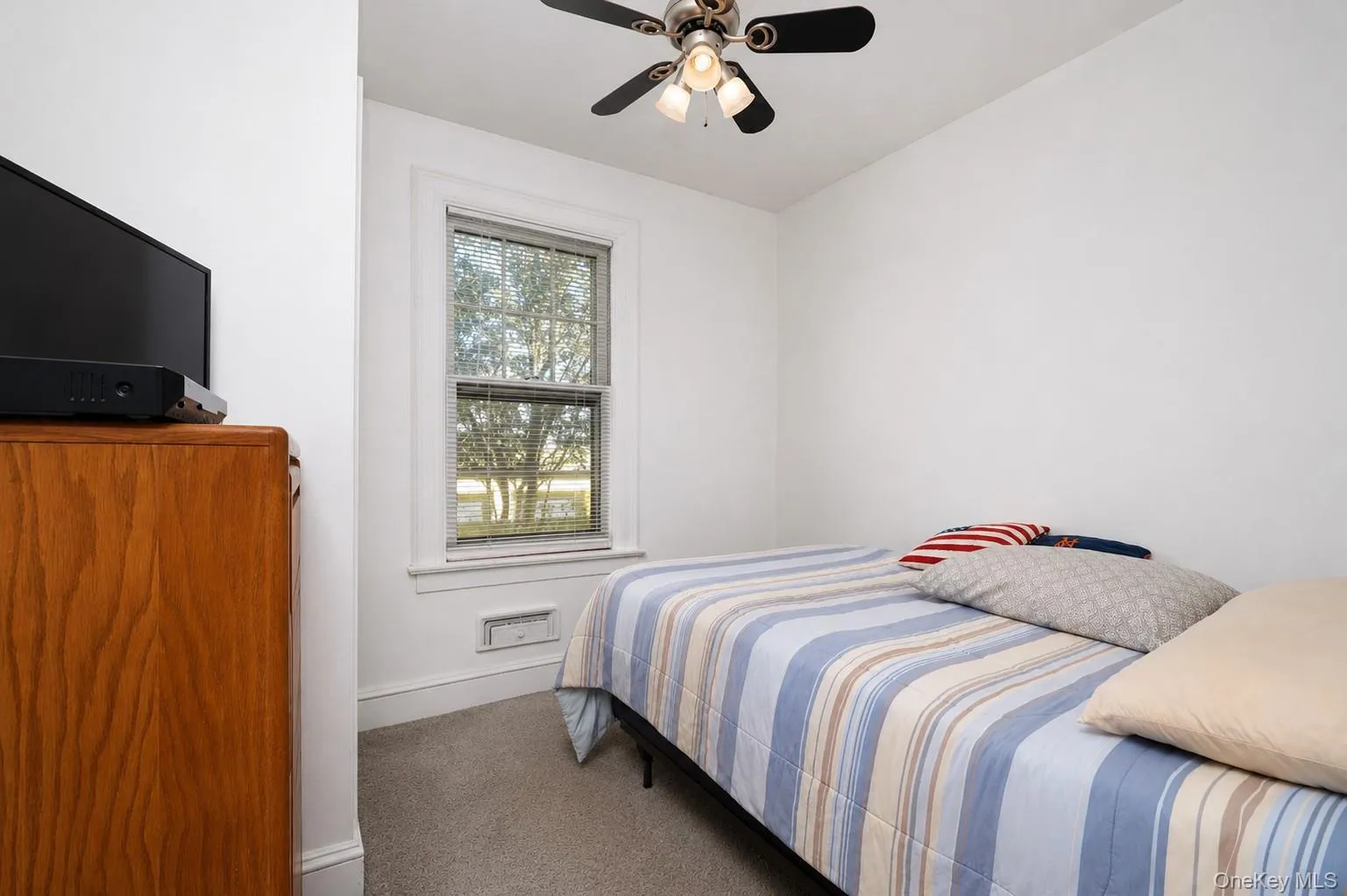 Neutral wall paint, ceiling fan with light fixture, window with blinds, and carpeted flooring Neutral wall paint, ceiling fan with light fixture, window with blinds, and carpeted flooring