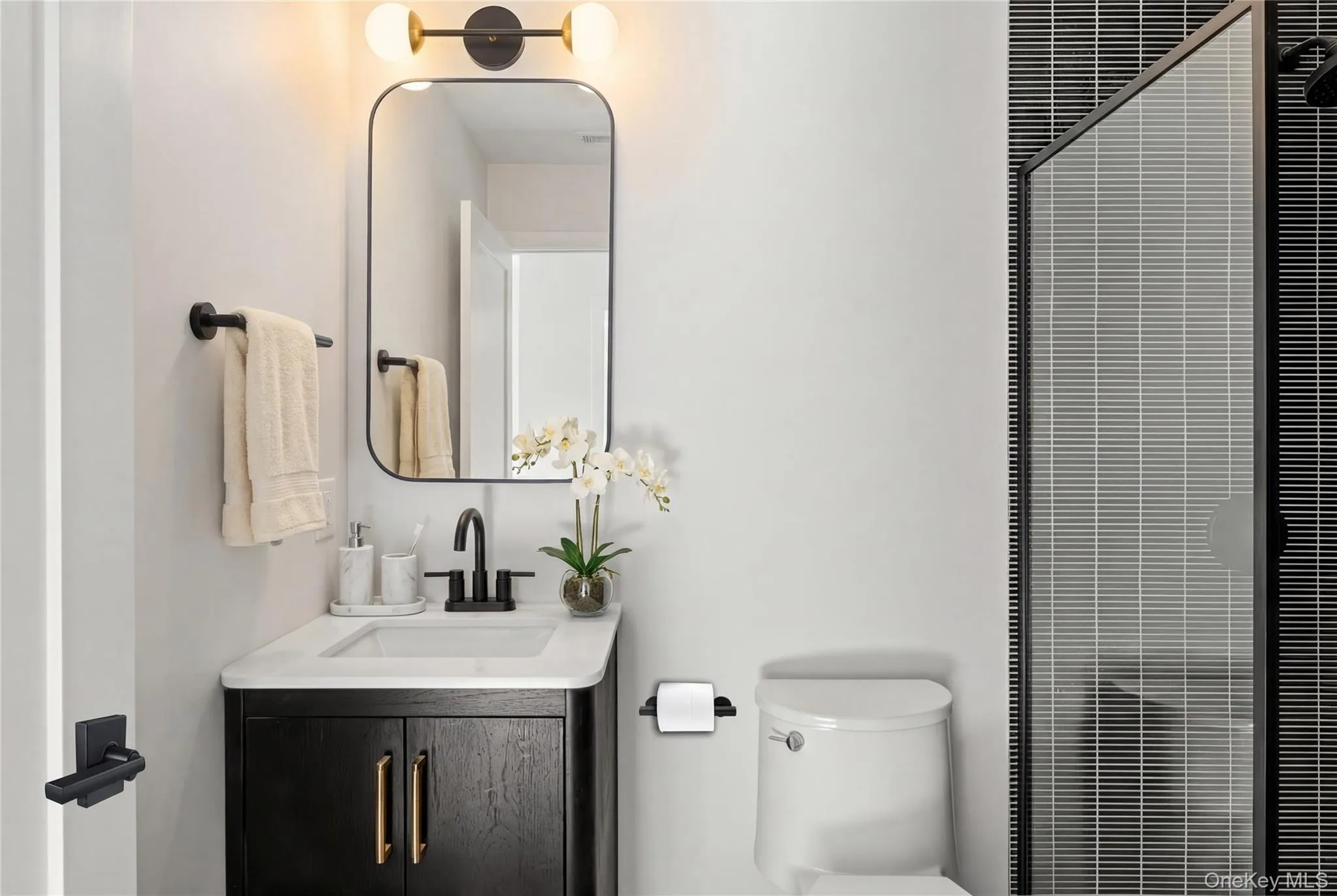 Powder Room - Black wood-finish vanity with white countertop, rectangular basin, and matte black faucet Powder Room - Black wood-finish vanity with white countertop, rectangular basin, and matte black faucet