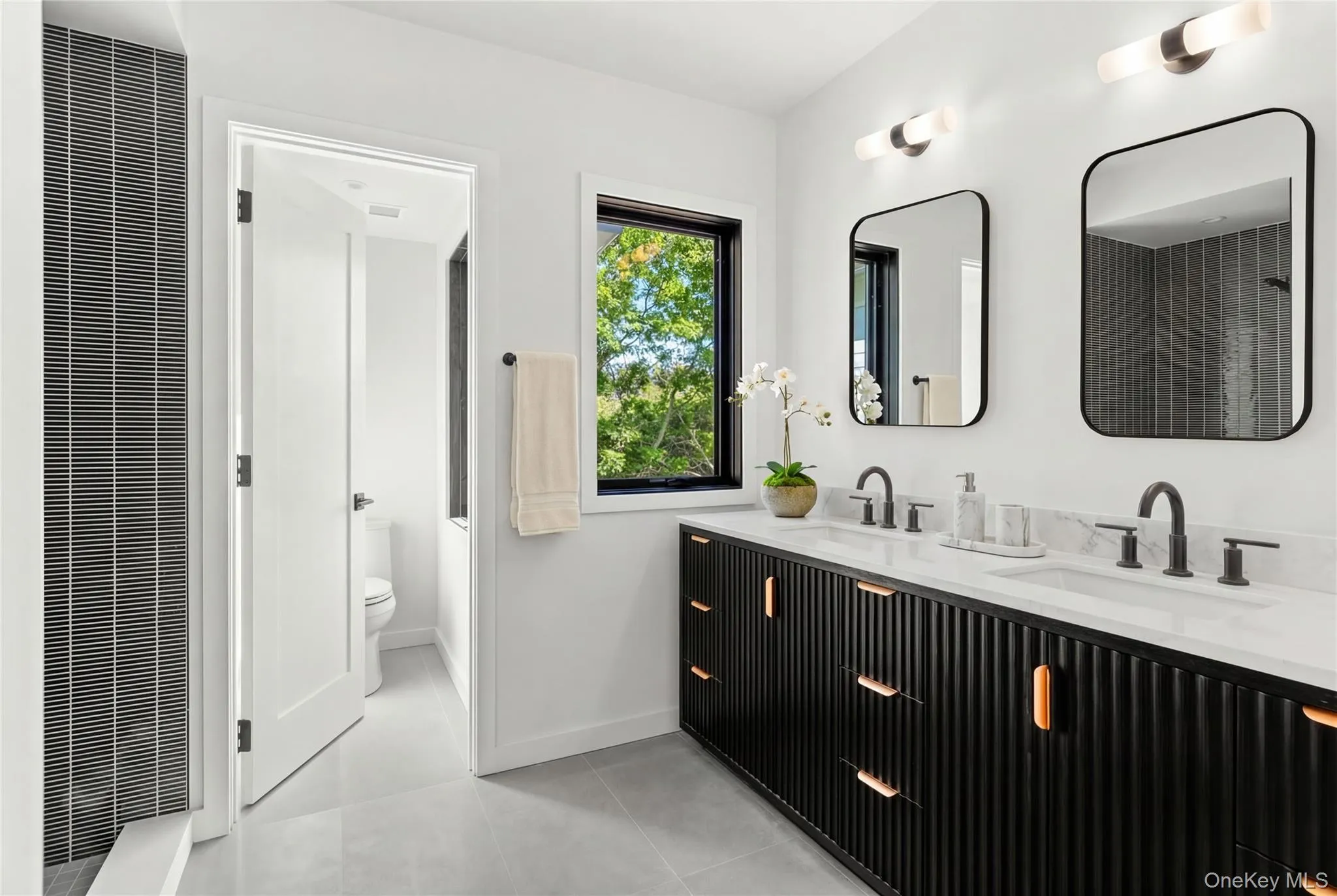 Dual vanity with white countertop and integrated sinks, matte black faucets, and rectangular mirrors Dual vanity with white countertop and integrated sinks, matte black faucets, and rectangular mirrors