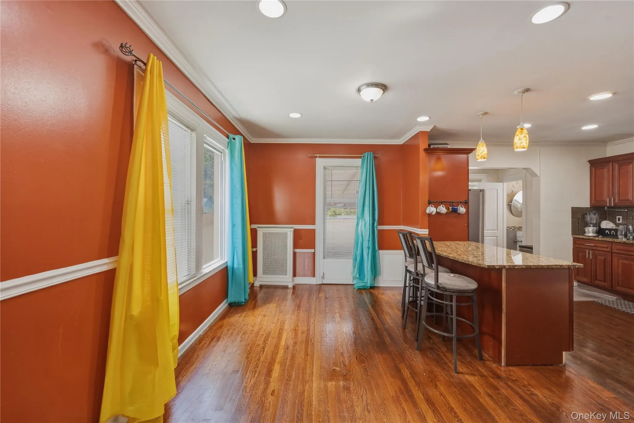 Hardwood flooring, crown molding, chair rail molding, recessed lighting, and a kitchen island with stone countertop Hardwood flooring, crown molding, chair rail molding, recessed lighting, and a kitchen island with stone countertop