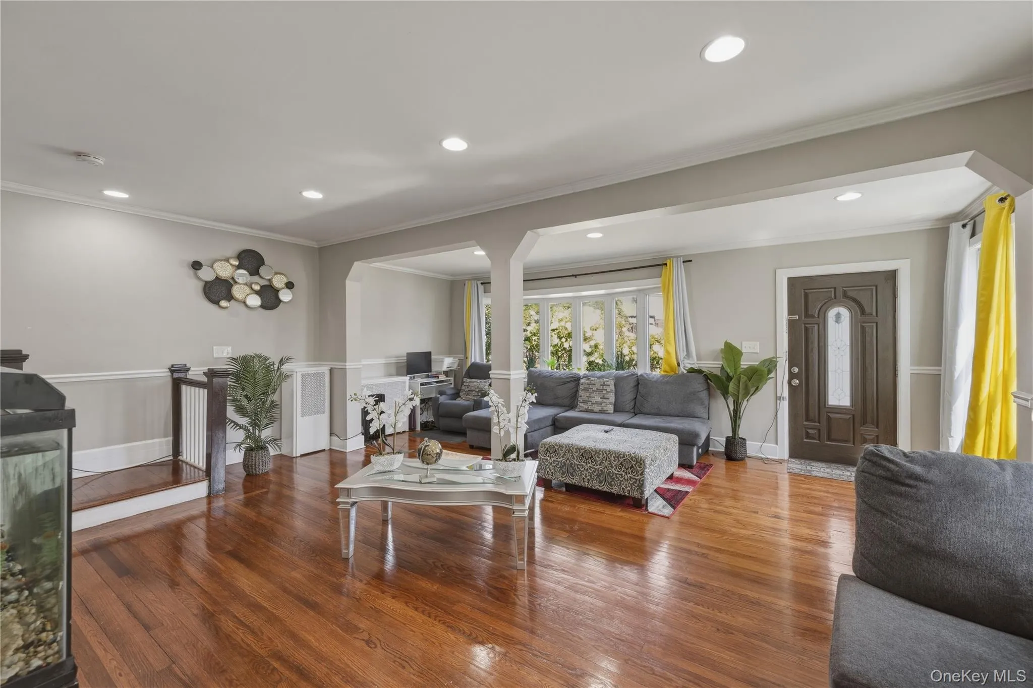 Recessed lighting in ceiling, wood-finish flooring, decorative entryway door, curved bay window, and archway structural details Recessed lighting in ceiling, wood-finish flooring, decorative entryway door, curved bay window, and archway structural details