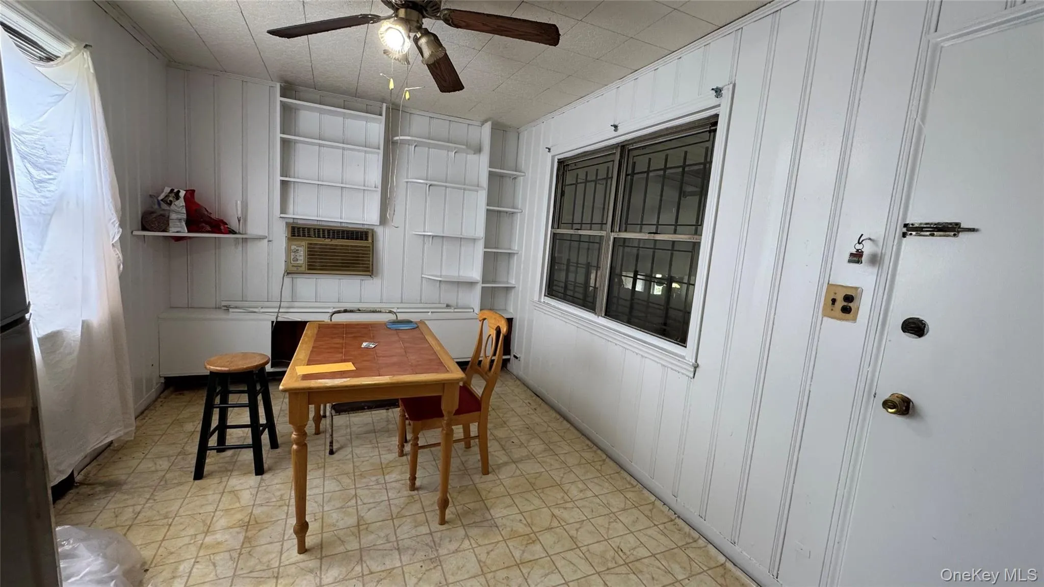 Window-mounted air conditioning unit, ceiling fan, and built-in shelving. Eat In Kitchen Window-mounted air conditioning unit, ceiling fan, and built-in shelving. Eat In Kitchen