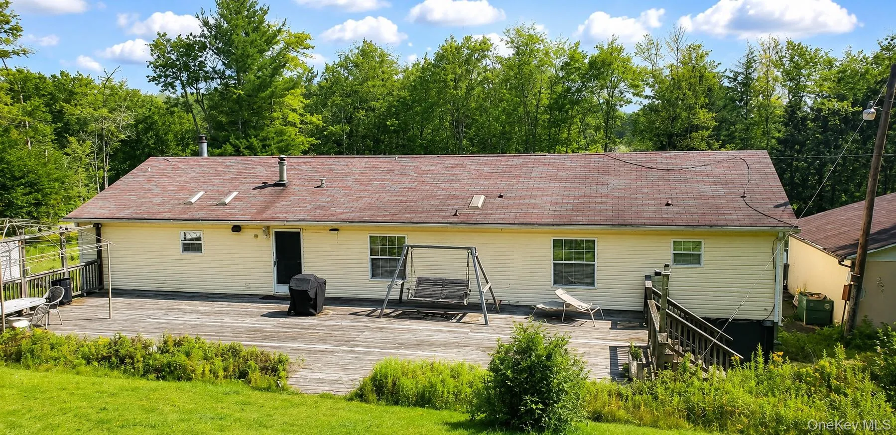 Charming single-story residence with yellow vinyl siding and dimensional asphalt shingle roofing Charming single-story residence with yellow vinyl siding and dimensional asphalt shingle roofing