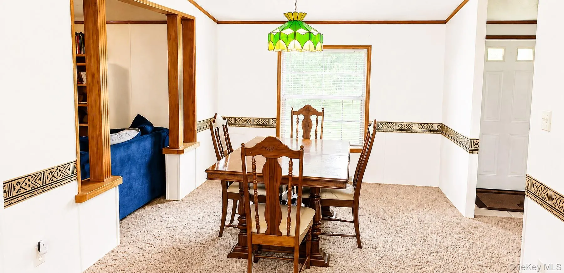 Carpeted dining area with a wood-trimmed window Carpeted dining area with a wood-trimmed window
