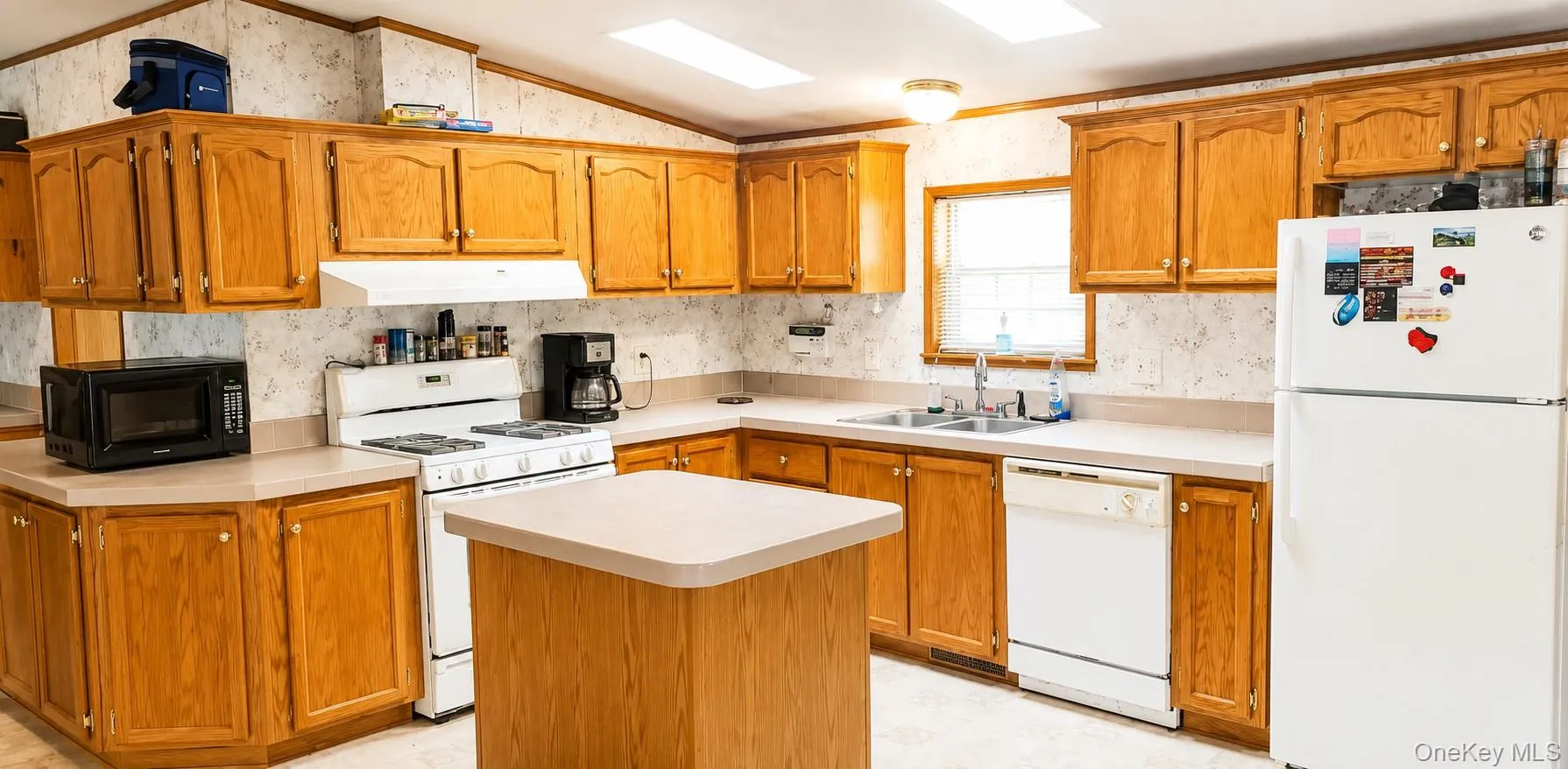 Kitchen featuring wood-finish cabinetry, a central island, and white appliances Kitchen featuring wood-finish cabinetry, a central island, and white appliances
