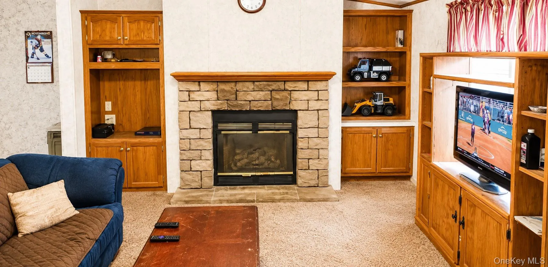 Stone-clad fireplace with a wood mantel Stone-clad fireplace with a wood mantel
