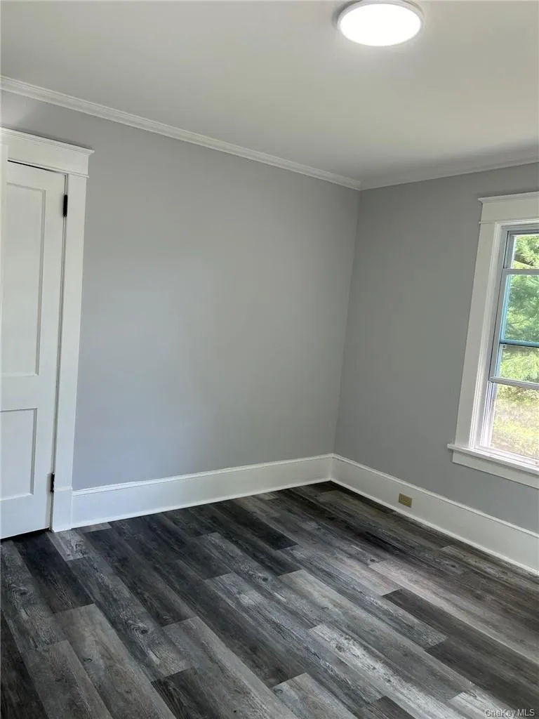 Bedroom with crown molding and grey vinyl plank floors Bedroom with crown molding and grey vinyl plank floors