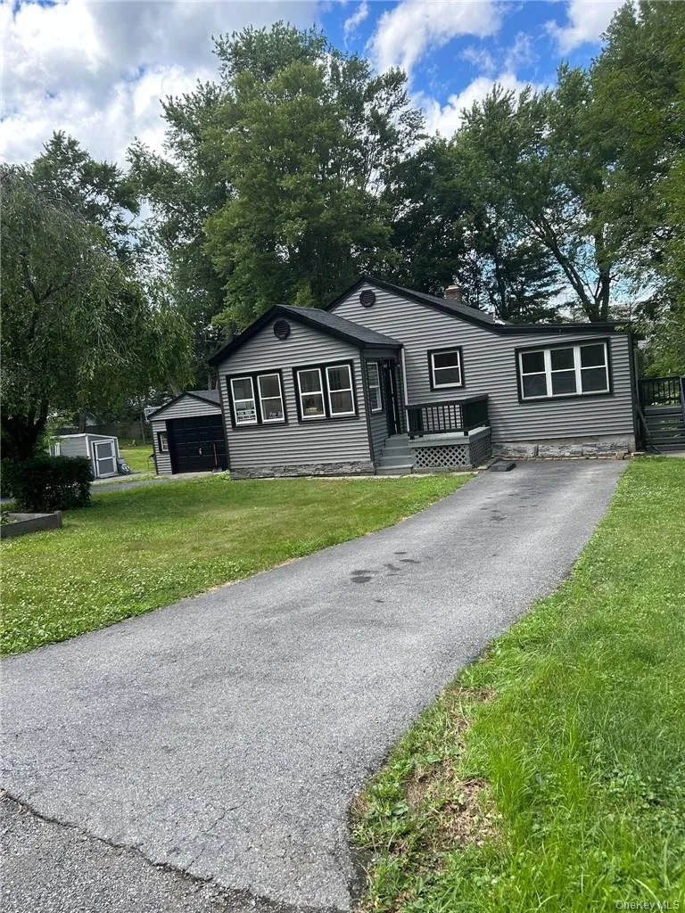 View of front of house featuring gray vinyl siding with black trim and a front lawn and Double Driveway View of front of house featuring gray vinyl siding with black trim and a front lawn and Double Driveway