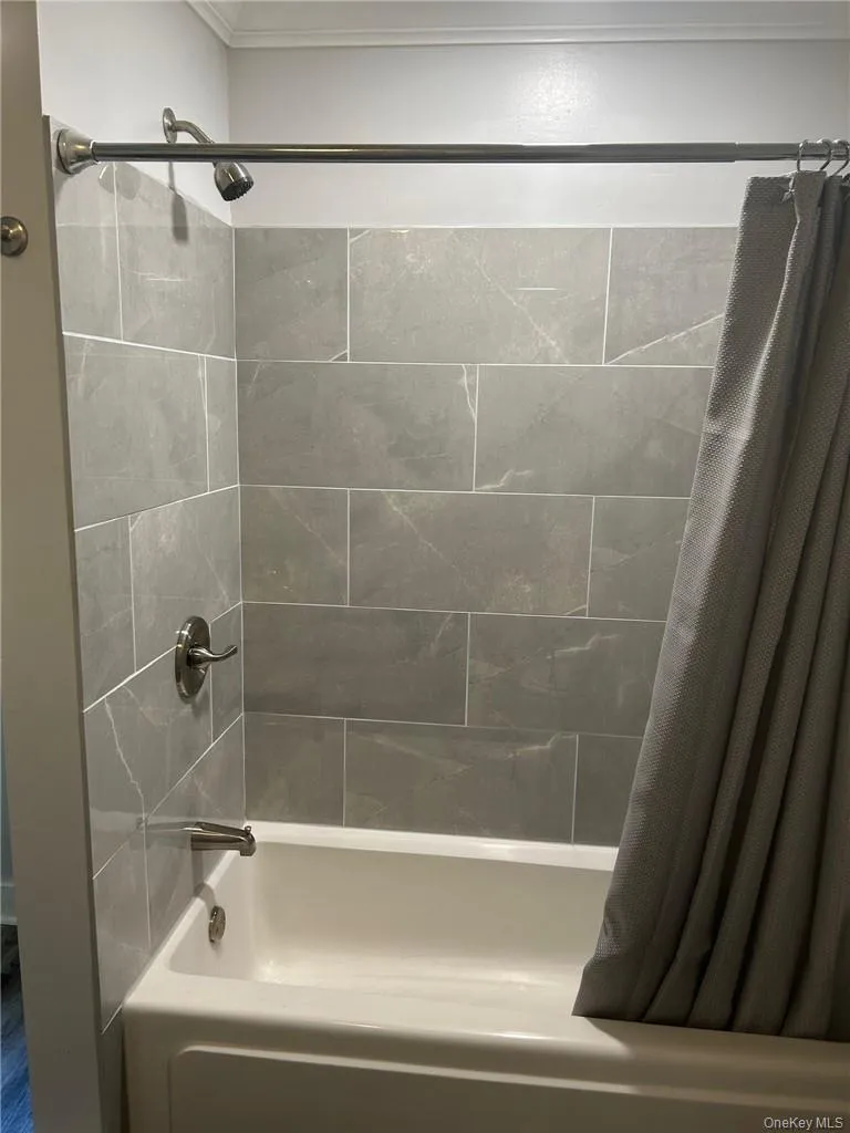 Bathroom featuring ceramic tile shower / bathtub combination with curtain Bathroom featuring ceramic tile shower / bathtub combination with curtain