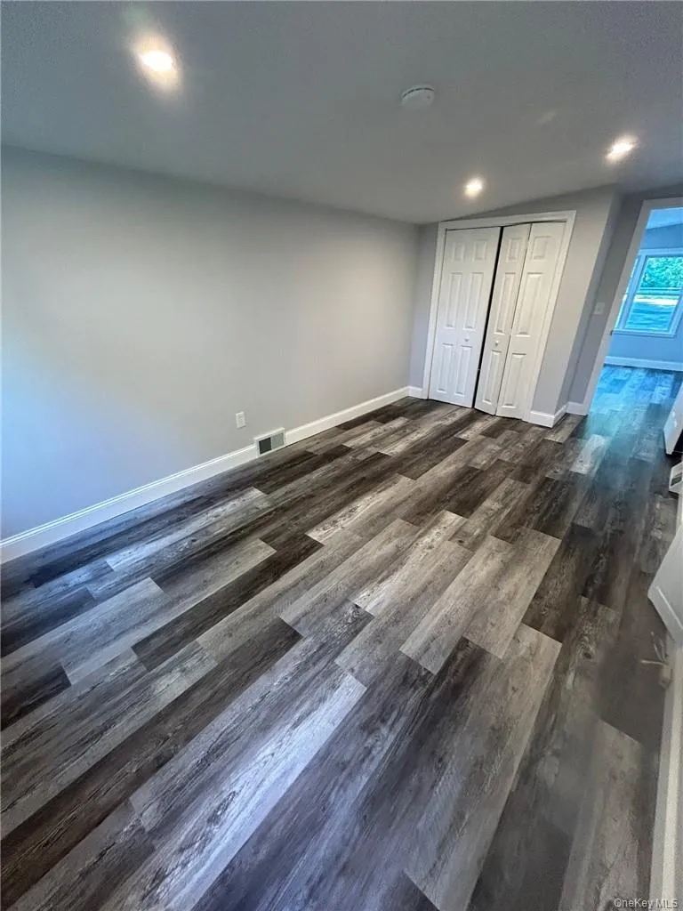 bedroom with a closet and dark wood-type flooring bedroom with a closet and dark wood-type flooring