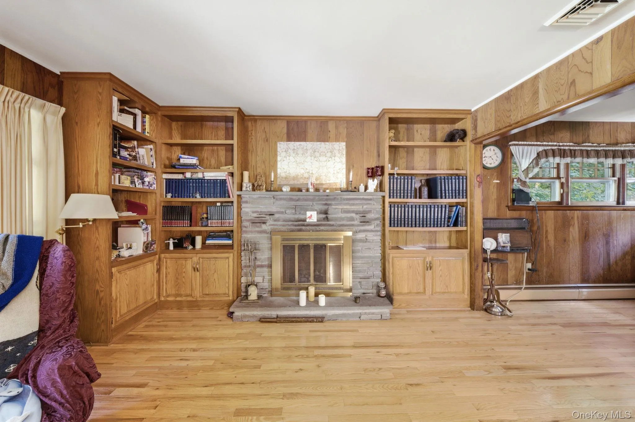 Living Room with Fireplace, built-in cabinetry, wood floors and paneling. Living Room with Fireplace, built-in cabinetry, wood floors and paneling.