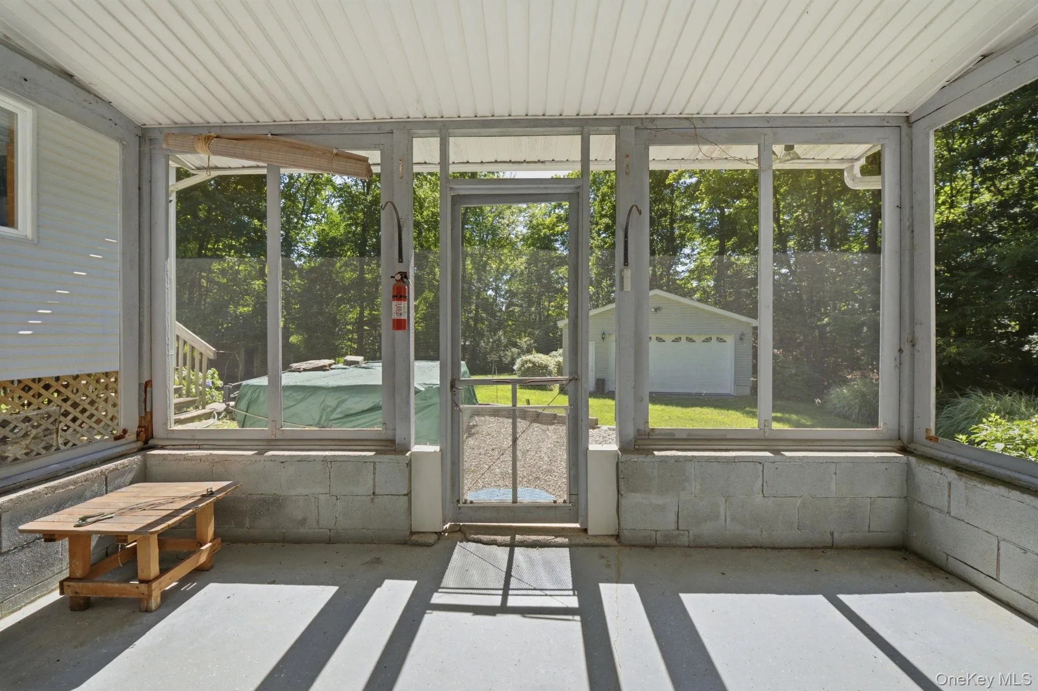 Screened-in patio looking onto back yard and deck with hot tub. Screened-in patio looking onto back yard and deck with hot tub.