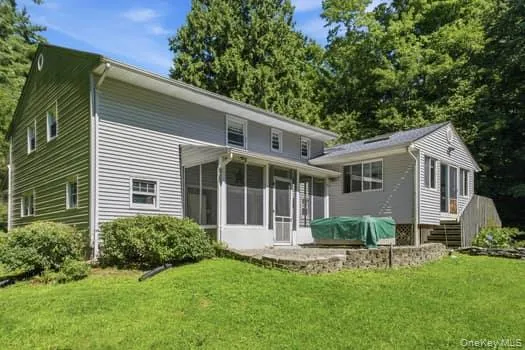 View of Back of home with hot tub on terrace, and screened porch. View of Back of home with hot tub on terrace, and screened porch.