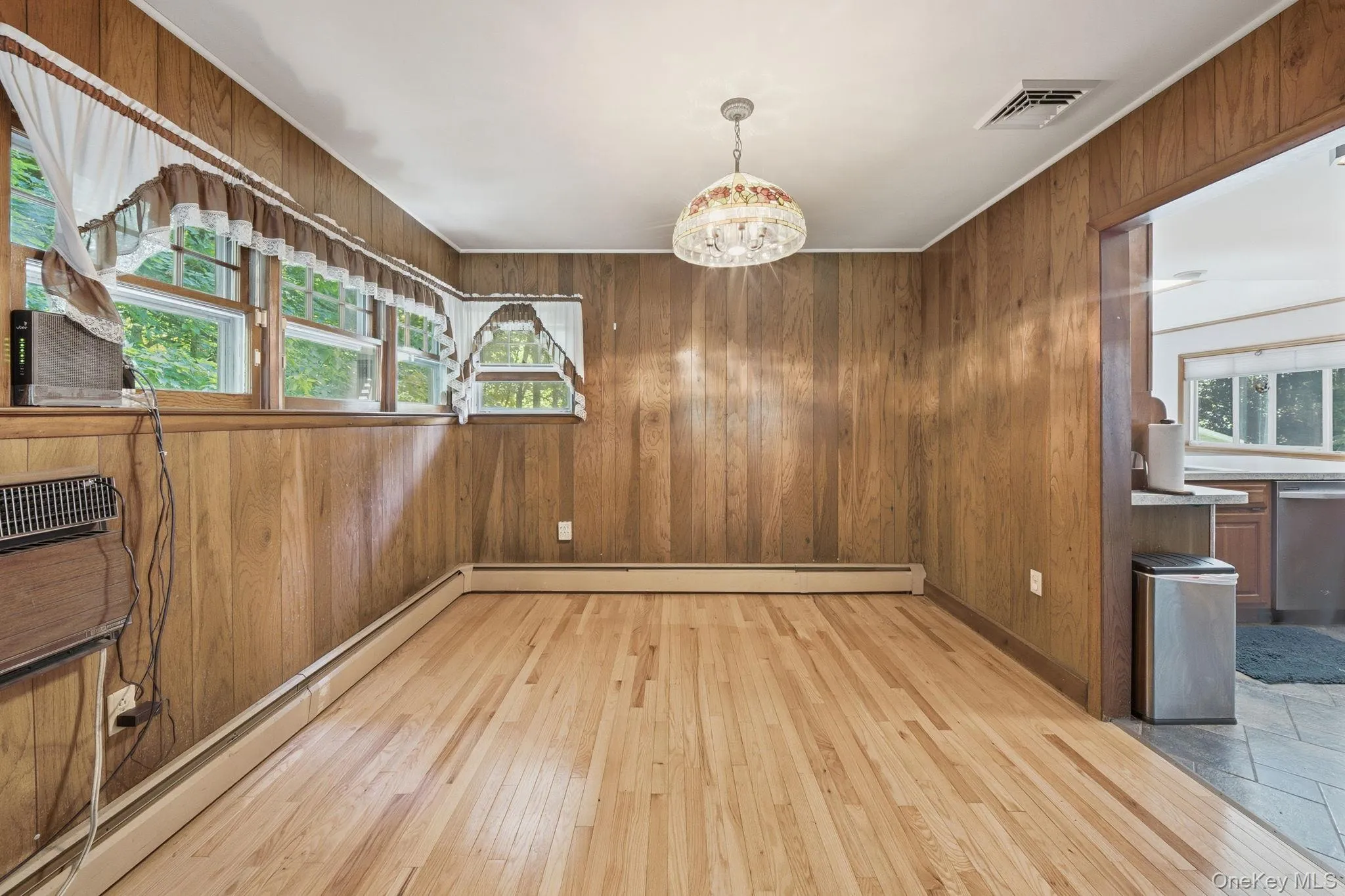 Dining Room with wood floors, paneling, and plenty of windows off the kitchen and living room. Dining Room with wood floors, paneling, and plenty of windows off the kitchen and living room.