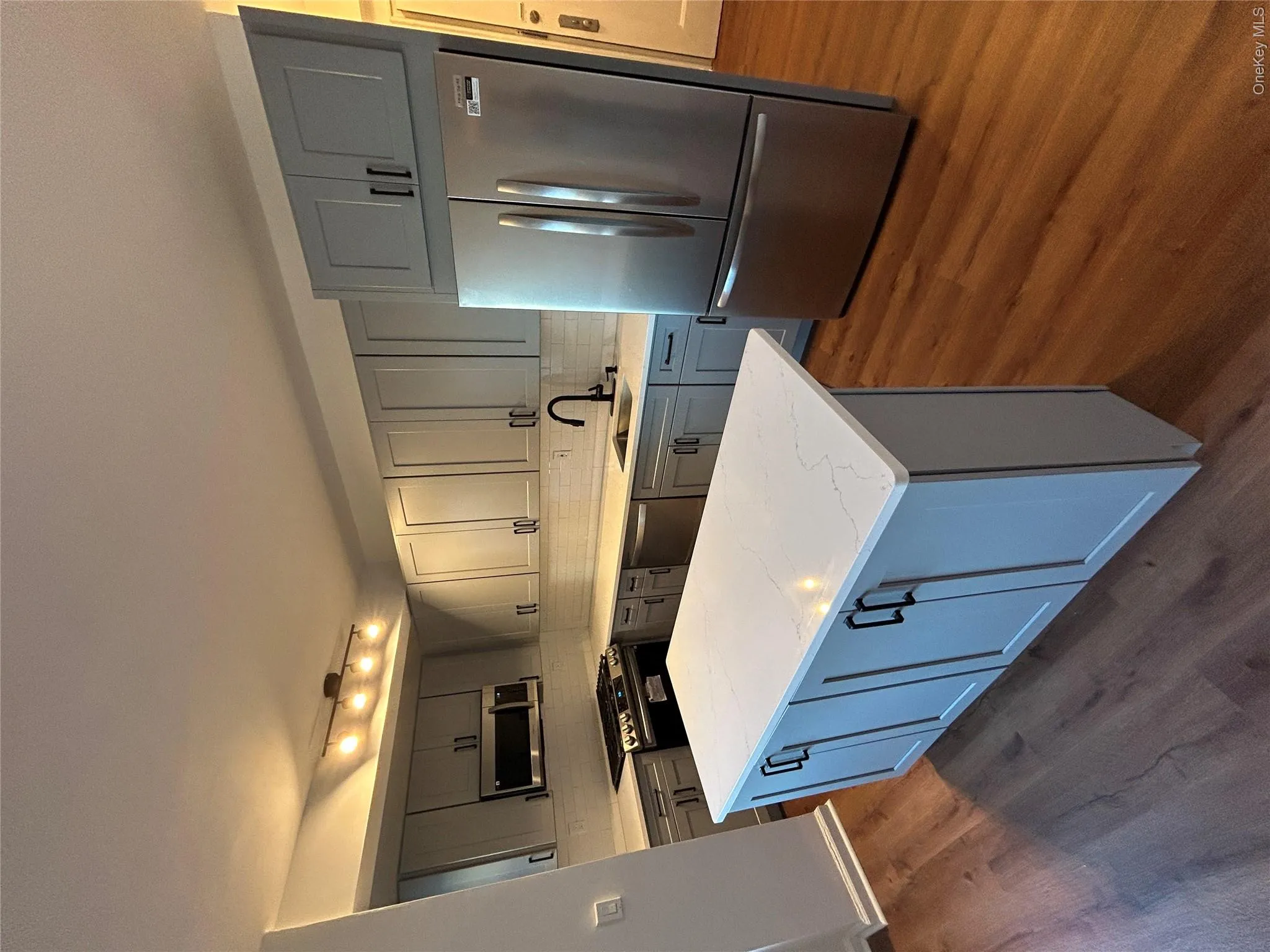 Kitchen featuring light stone countertops, sink, stove, fridge, and dishwashing machine Kitchen featuring light stone countertops, sink, stove, fridge, and dishwashing machine